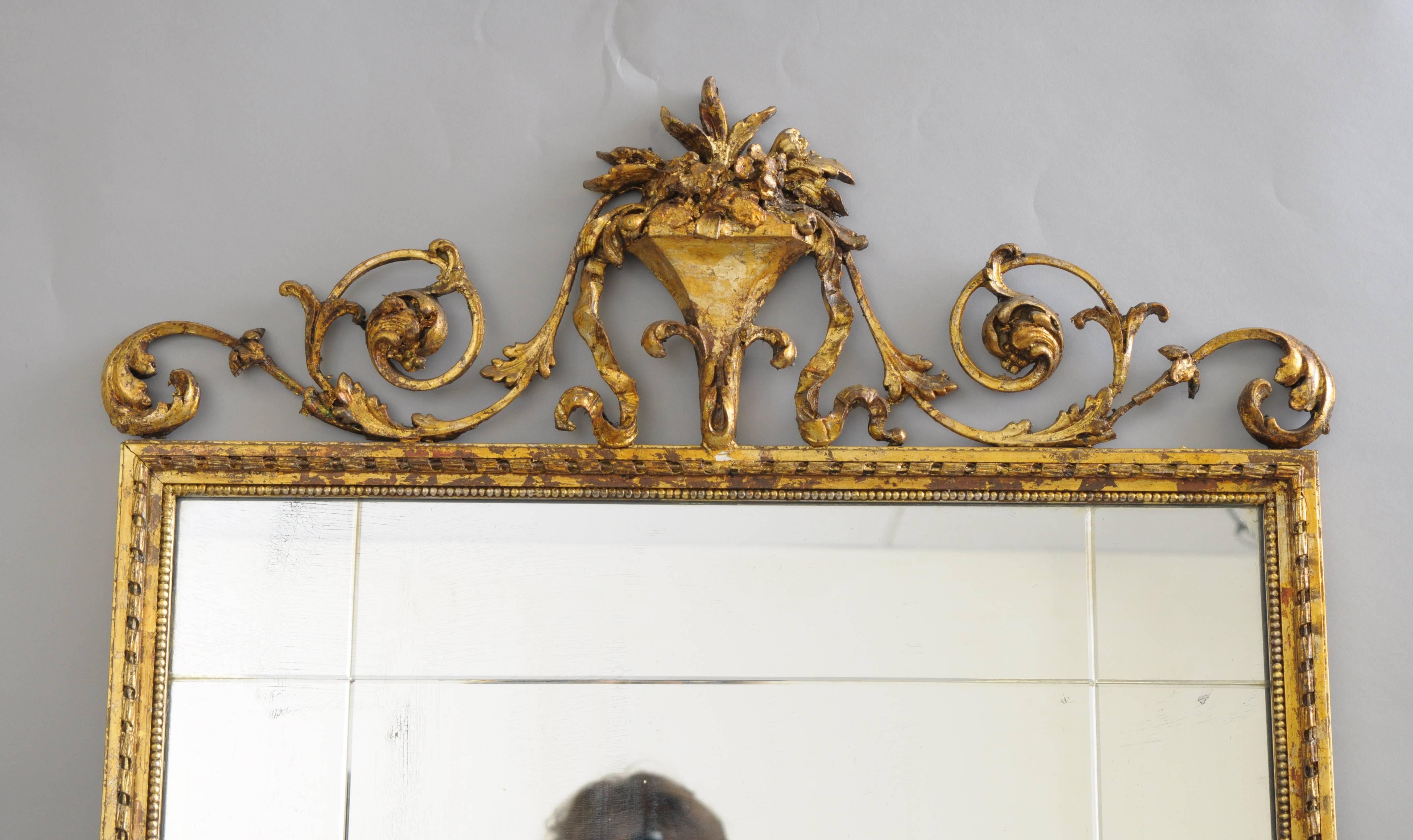 Early 20th Century carved gold giltwood and gesso English Robert Adam style rectangular wall Mirror. Item features an iron and gesso blooming floral bouquet with draping acanthus leaves and bell flowers. The giltwood and gold leaf frame displays