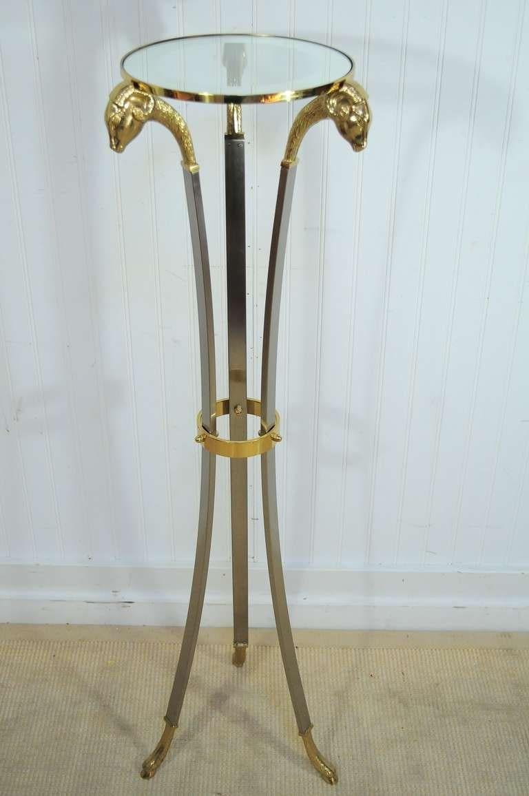 High Quality Vintage Italian Made Neoclassical / Regency Style Pedestal Table in Steel and Brass with Rams Heads - Made in Italy. Item features Tall Slender Neoclassical Style Tripod Frame, Triple Rams Heads, Hoof Feet, Mirror Bordered Glass Top,