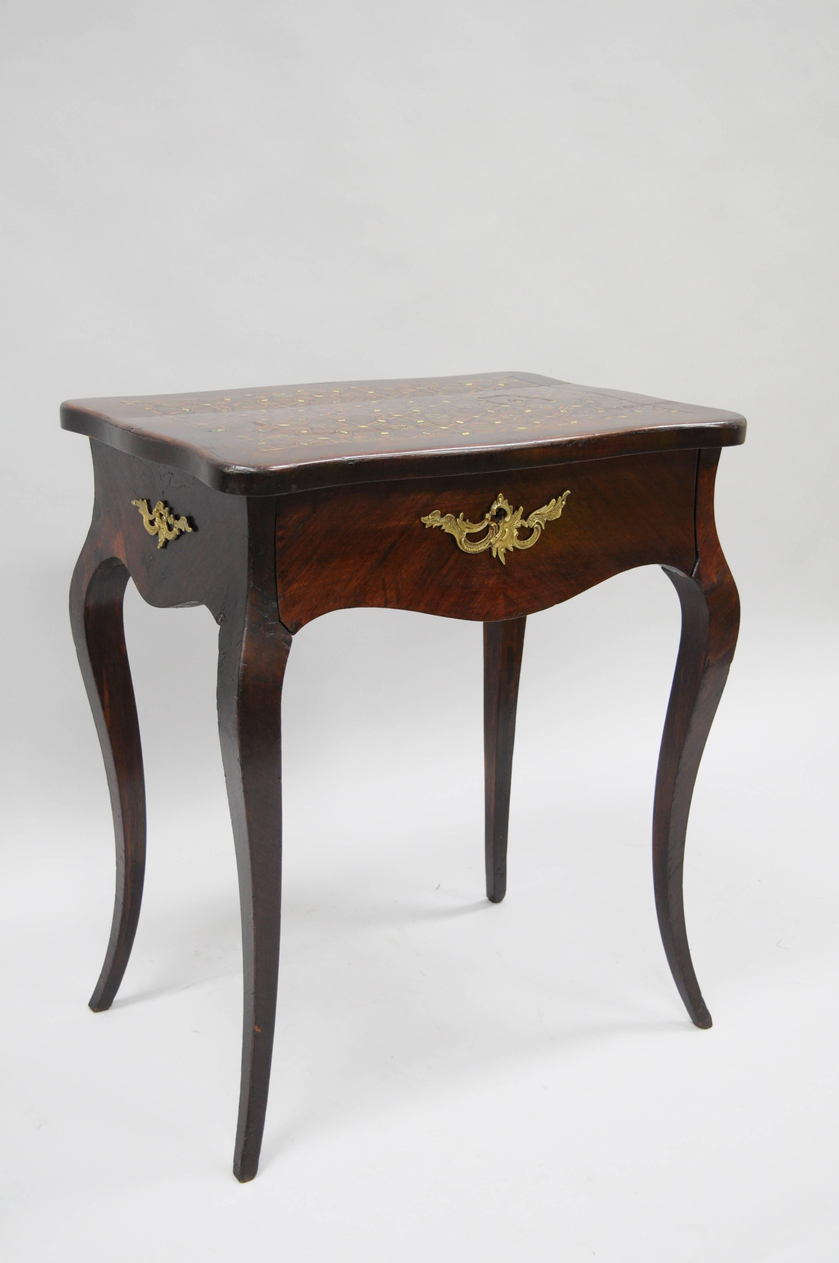 Antique 19th century French Napoleon III rosewood sewing table with ornate brass and mother-of-pearl marquetry inlaid top. Item features shapely cabriole legs, beautiful rosewood veneers, dovetailed central drawer and bronze ormolu. The ornate top