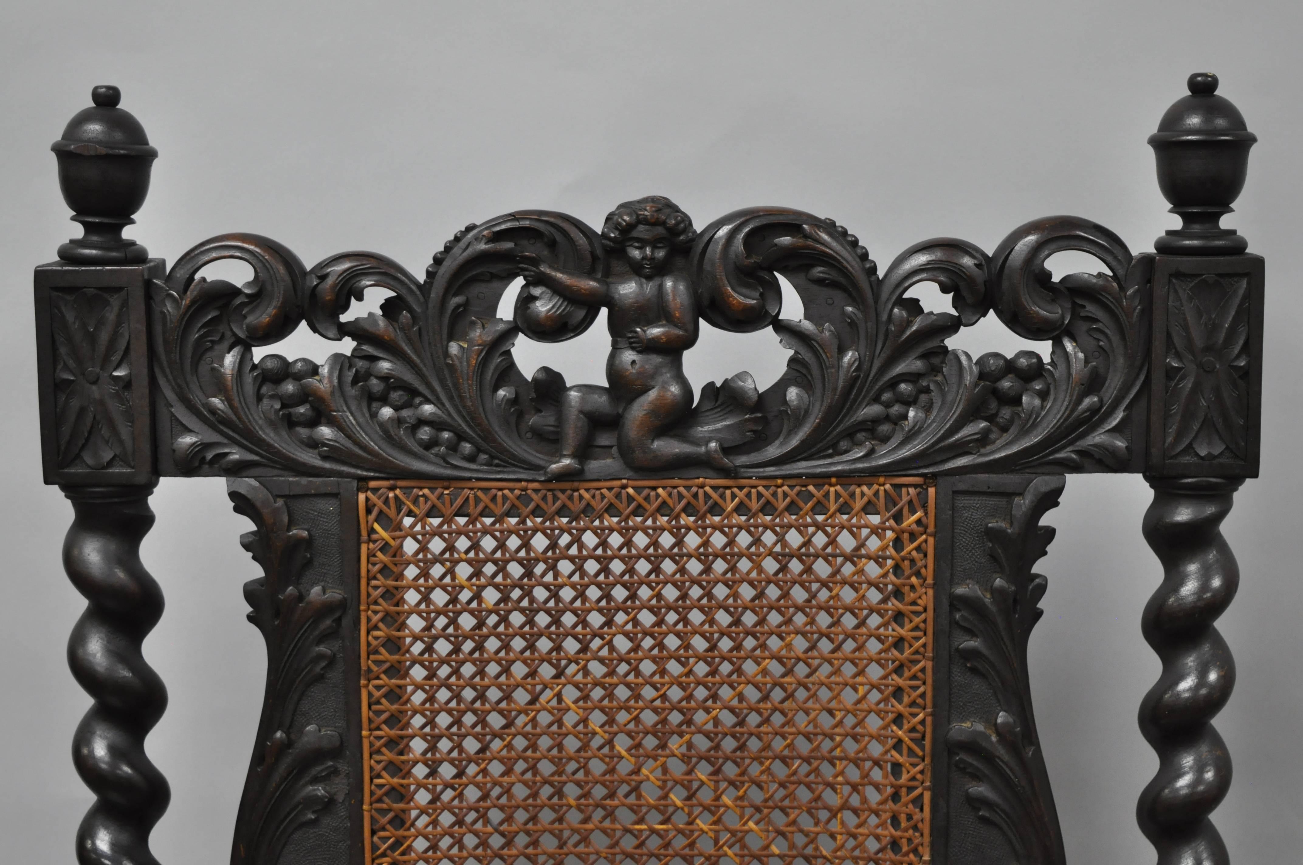 Stunning 19th century Jacobean / Renaissance Revival carved walnut armchairs. Chairs feature ornate spiral carved barley twist walnut frames with leafy scroll work, cherub figures on the upper rail and lower stretcher, tall cane back and seat, and