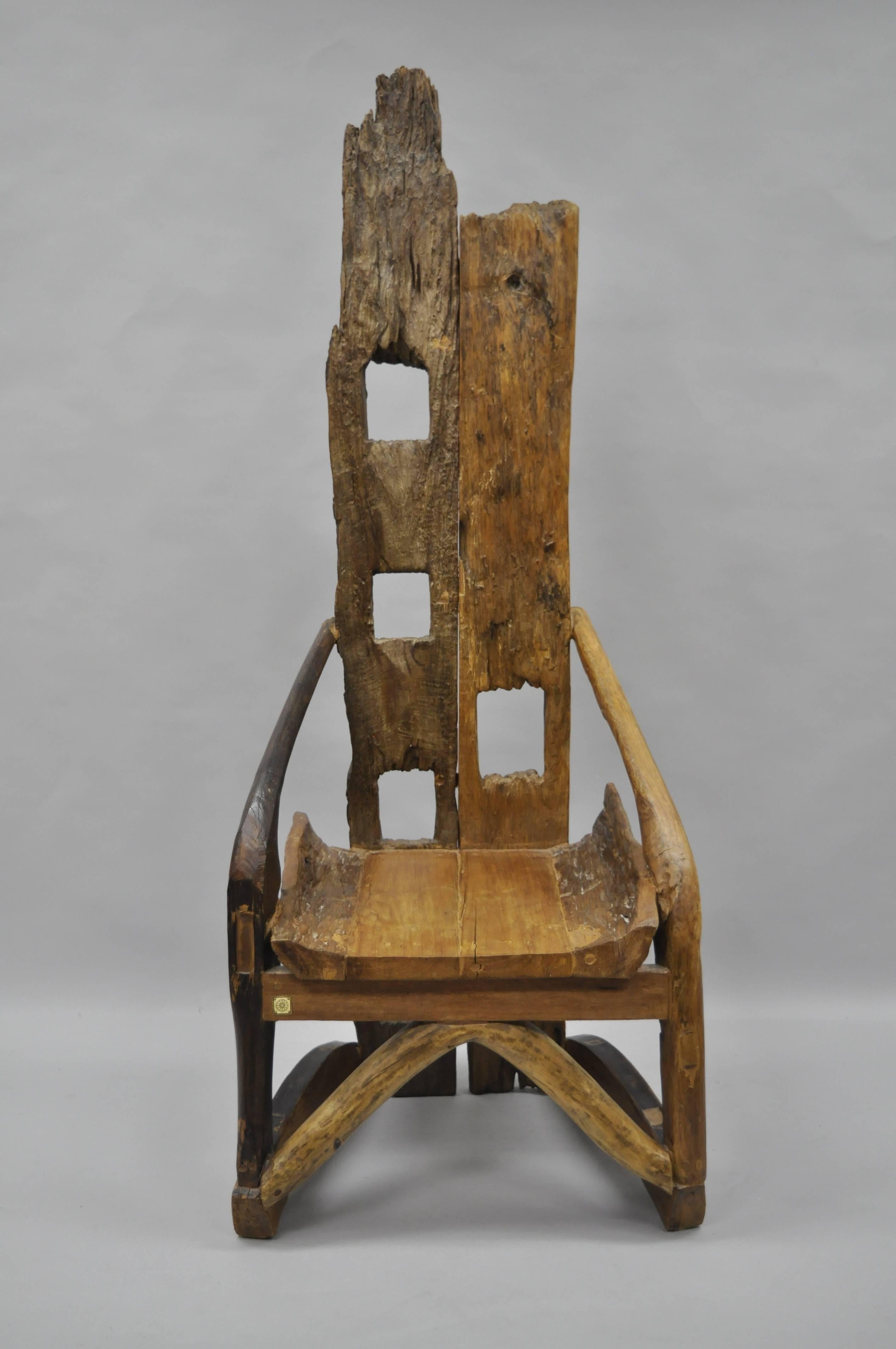 Unique high back sculptural tree log free-form lounge chair. Item features a tall substantial form, cut-out designed back, angled arms, stretcher base, and great naturalistic style. Metal tag to front but maker is unconfirmed.