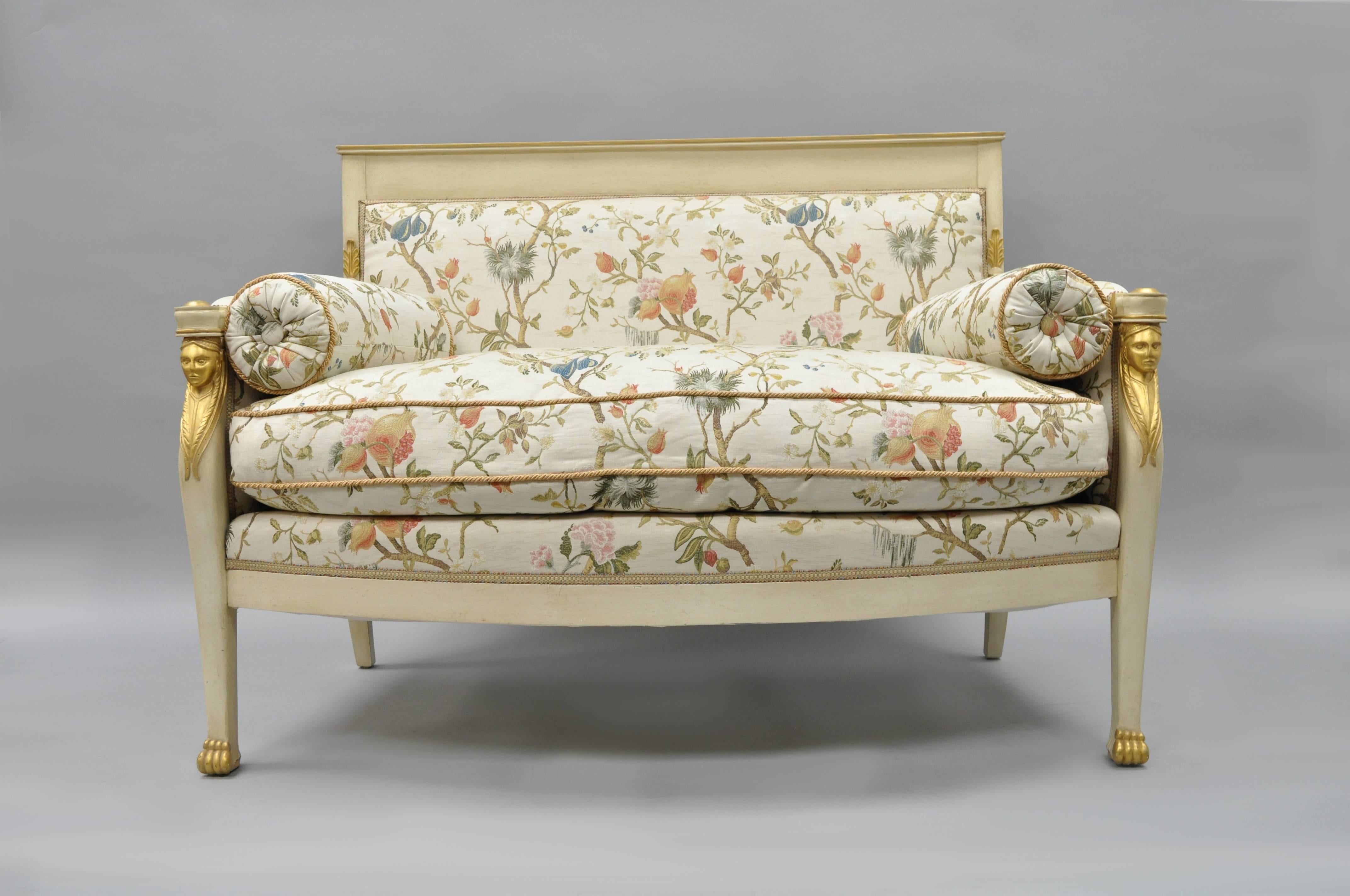 Stunning Early 20th Century French Neoclassical / Empire style figural gold gilt and cream painted settee covered in newer silk Scalamandre fabric with roped trim and down filled loose cushion. Item featured a solid carved wood frame, paw feet,