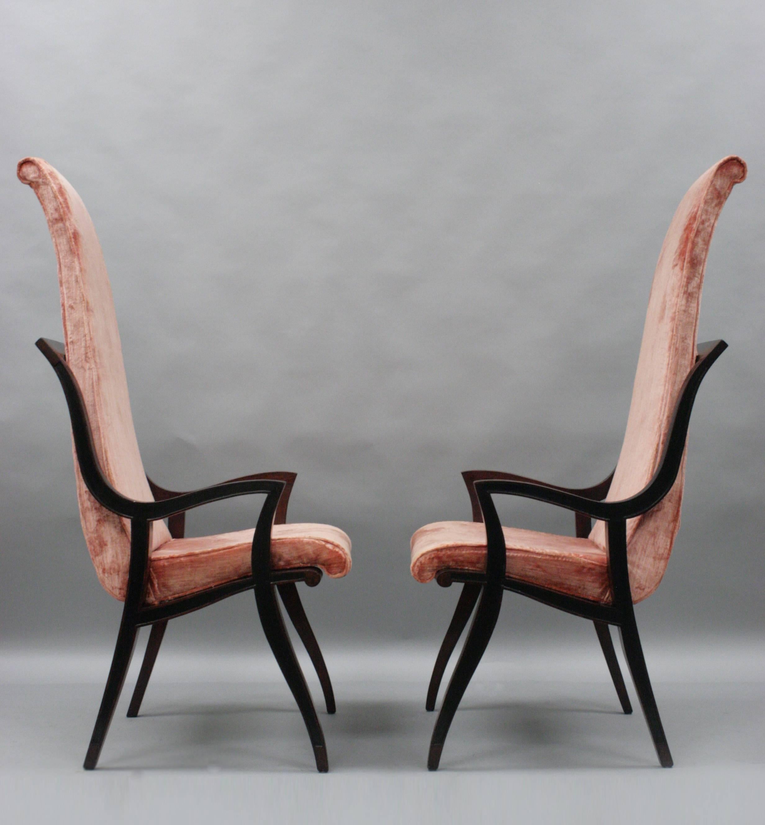 Pair of vintage Mid-Century Modern dining arm chairs with tall backs and sculpted wood frames. The pair features shapely solid wood construction, rolled backs and great whimsical form. The designer is unconfirmed but the style and form is similar to