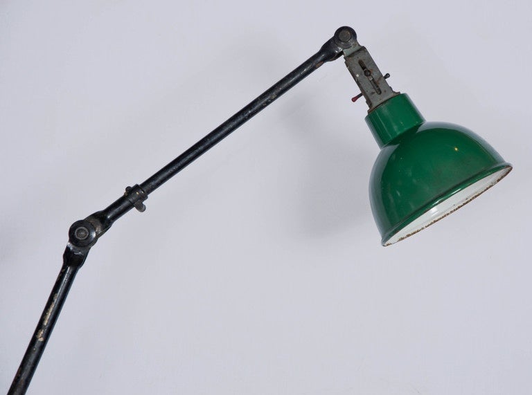 An original industrial floor light circa 1930s. This vintage articulated light was manufactured by UK based industrial lighting specialists Dugdills, as indicated by the maker's mark on the cast base. The light has a steel construction with an