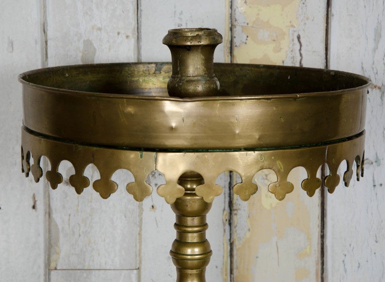 A decorative floor standing candelabrum in solid brass. This candle stand was reclaimed from a Greek orthodox church in London. The circular top would have been filled with stand to support thin candles, and a large central candle in the middle.