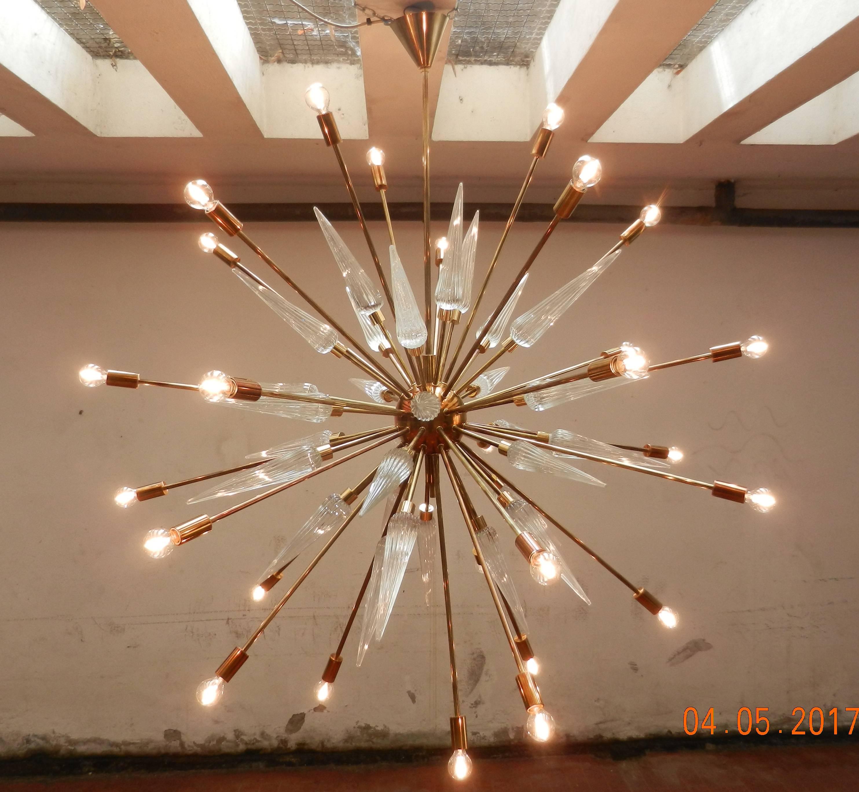 A Sputnik Murano glass chandelier, made with patinated brass and 30 Murano spiked cones with ridges generating from a brass centre ball.
Thirty-light fixtures generating from brass metal spikes.
Diameter 125 cm
The overall height 135 (cm can be