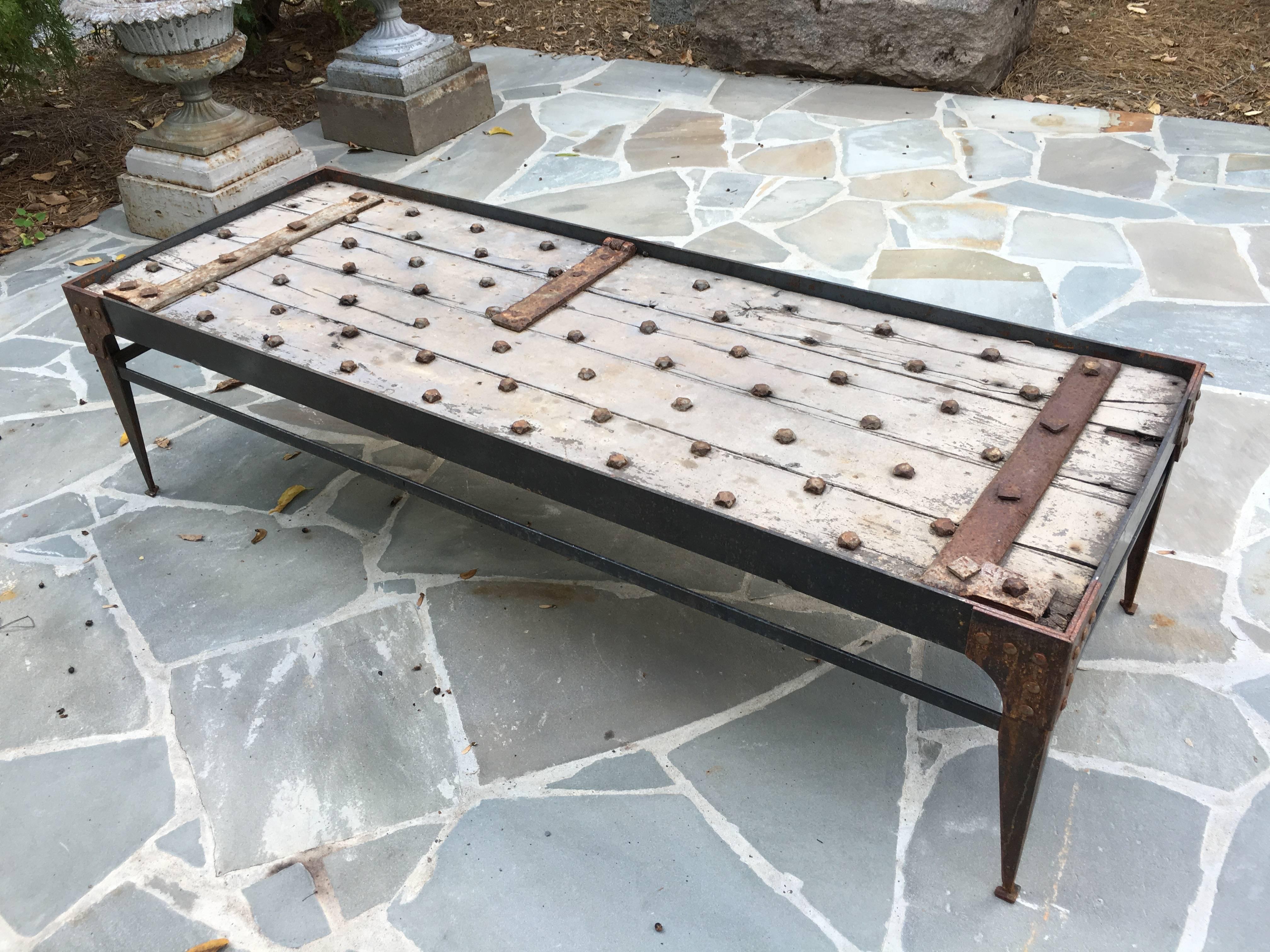 Incredible 18th century French door newly made into a coffee table with riveted iron. Door fits just below the surface so a glass top may be added.