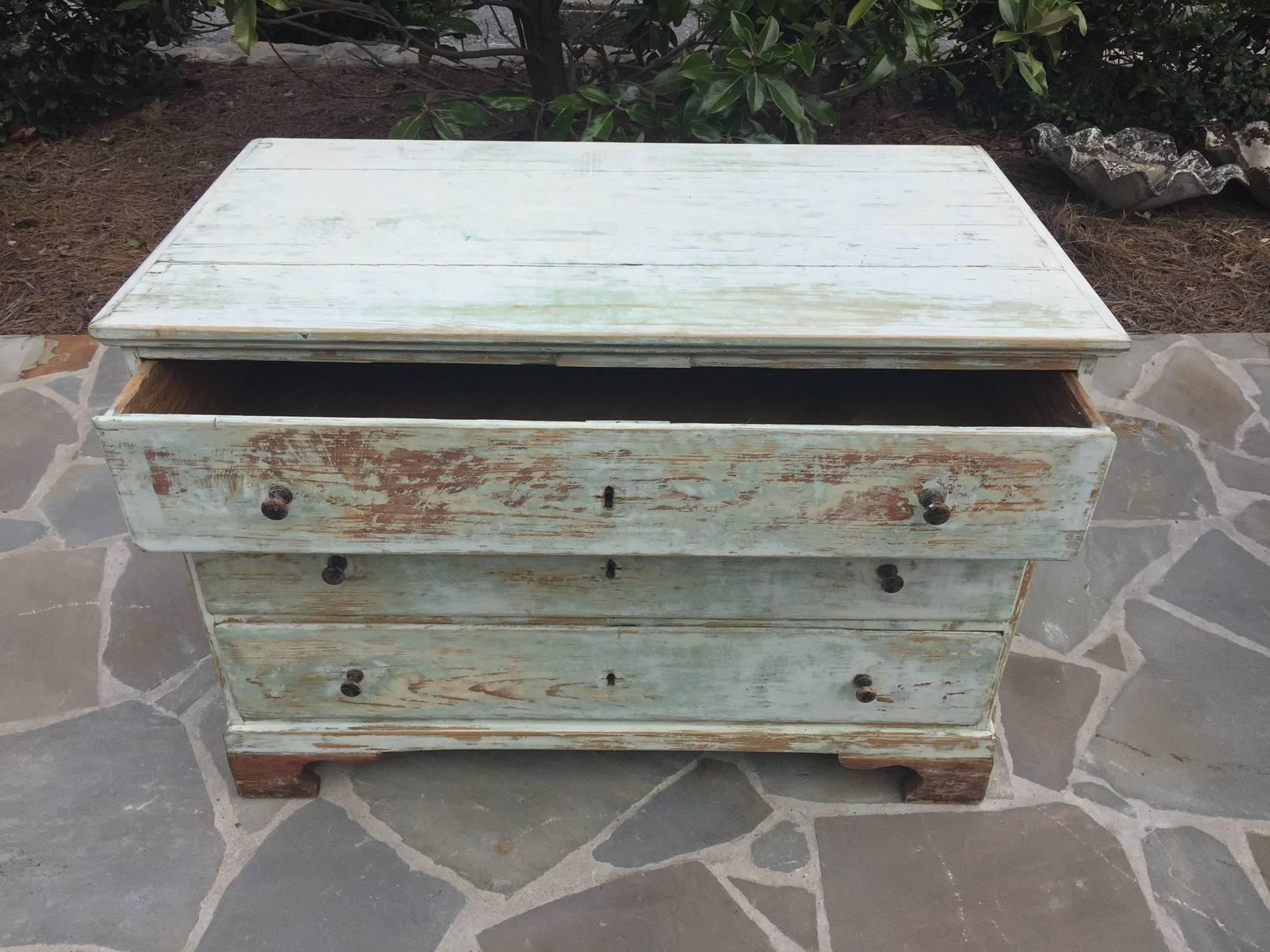 A Swedish 19th century Gustavian style chest, circa 1850. This Swedish three-drawer chest features nice clean lines, a grey blue painted wood color with wood showing through, wood pulls and carved legs.