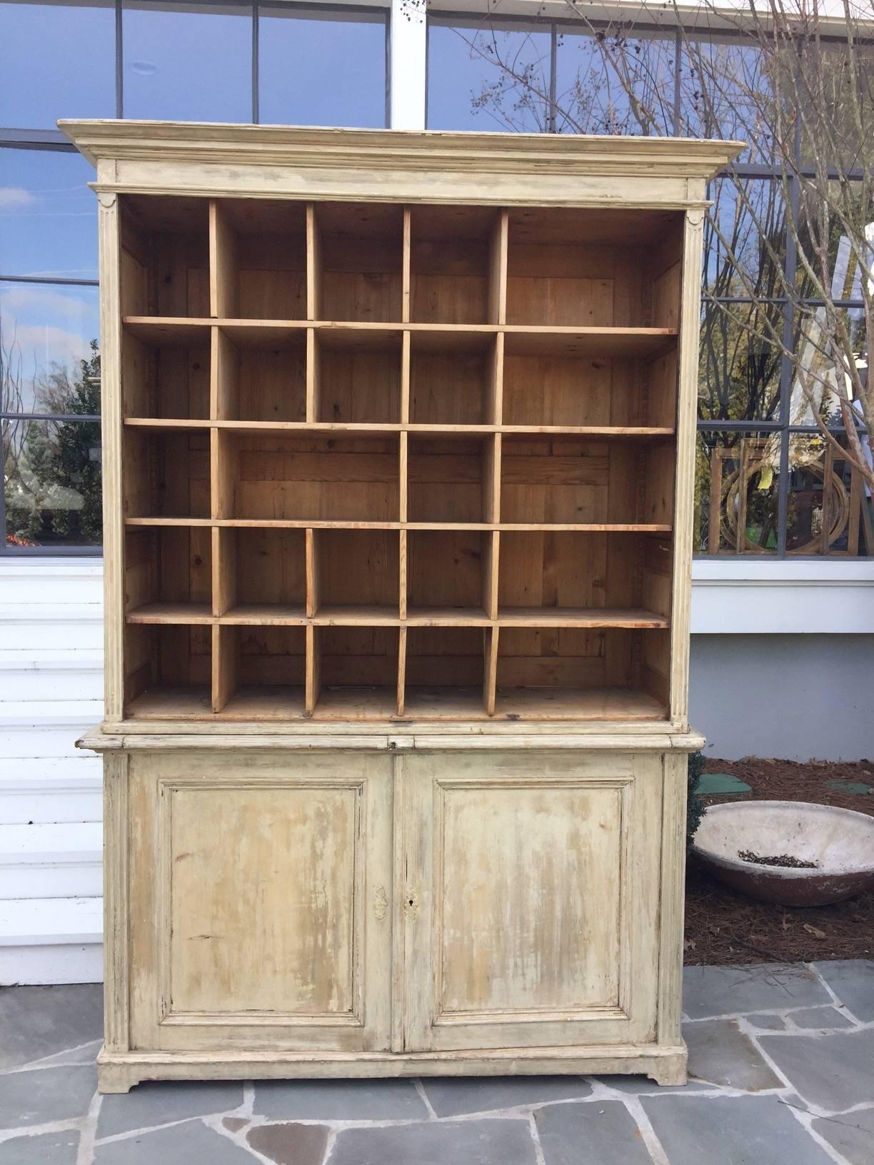 19th century French cabinet with pull out boards. This piece is in two parts and likely originated as a shop piece. The pullout boards were used to stack and sort inventory. The paint has been scarped to its original patina and it has lovely reeded