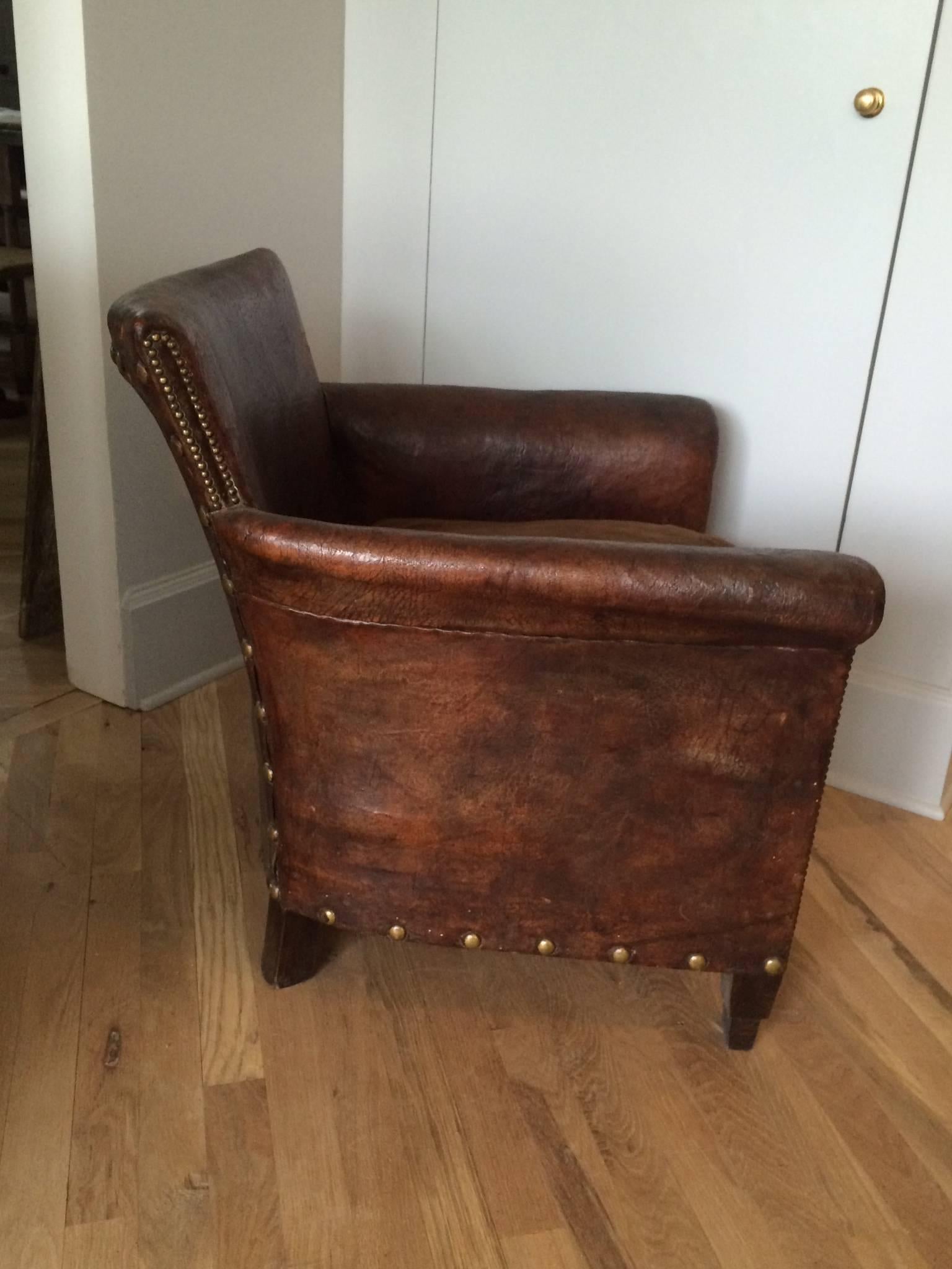 Wonderful patina on this all original leather club chair with large brass nailheads. Very comfortable original down filled velvet cushion.
