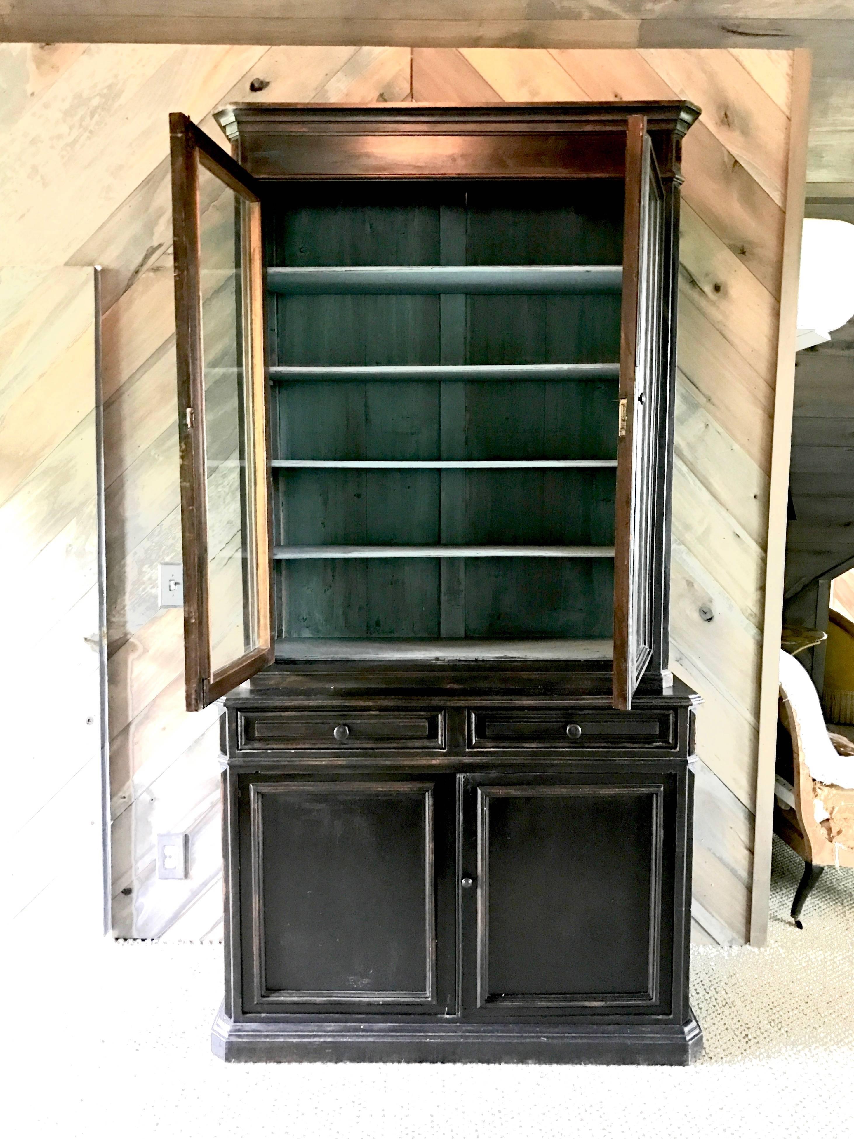 19th century antique Louis Philippe period painted bookcases, circa 1840.

These feature original glass doors above and storage cabinets below, both of which open to amply shelved blue painted interiors. One case features two pull-out boards.