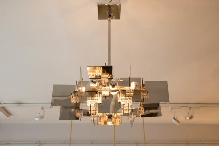 A  9 lights chandelier,
 Chromed steel, lucite and brass details .
Designed by Gaetano Sciolari
Italy, Circa 1960