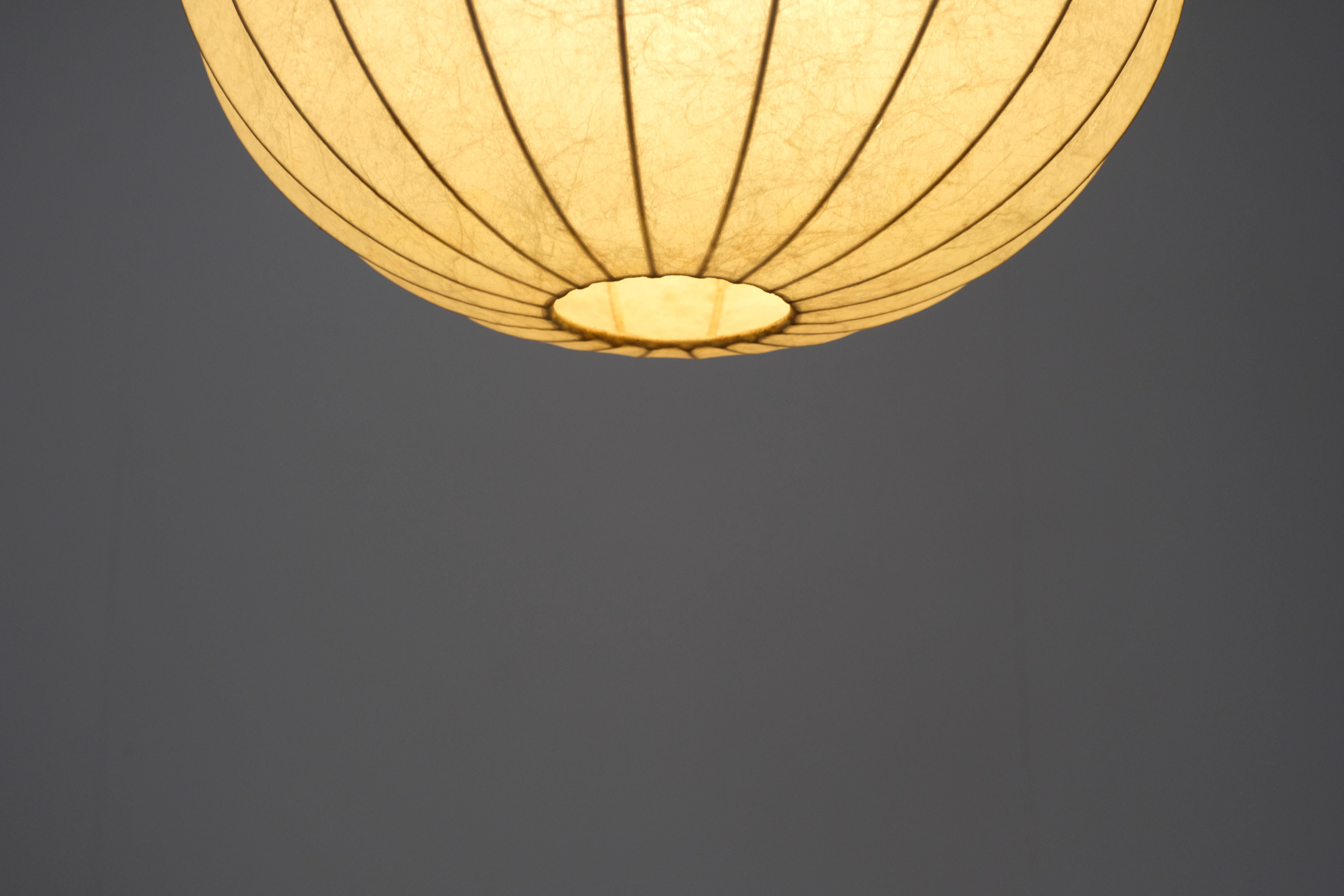 Magnifica lampada a sospensione Cocoon disegnata da Achille e Pier Giacomo Castiglioni per Flos negli anni '60.

Si tratta di un modello di piccole dimensioni con un diametro di 35 cm.

Questa lampada a sospensione presenta uno scheletro in metallo