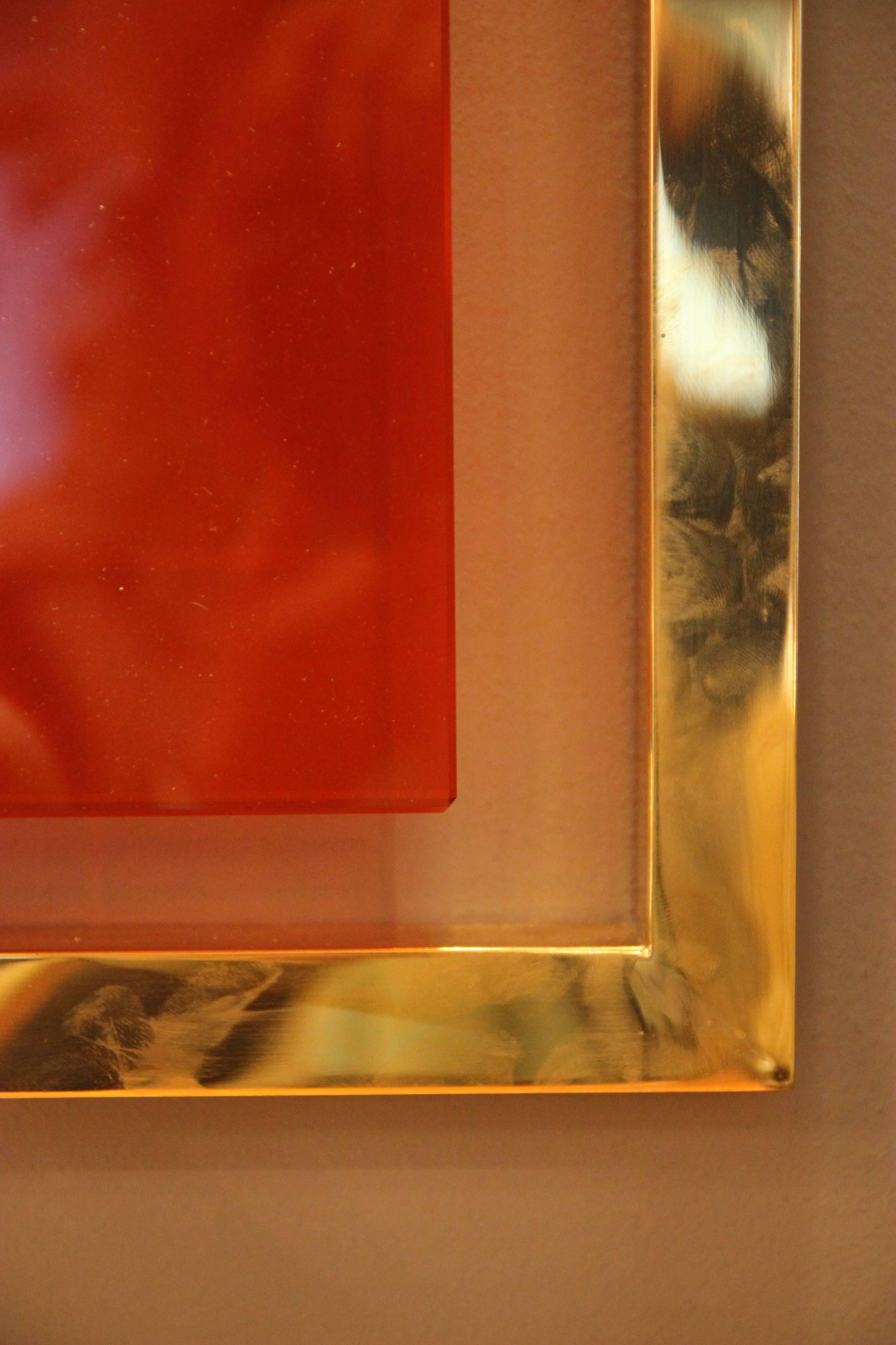 Contemporary Wall mirror, Gold-plated brass and orange glass, Circa 2010, Italy.