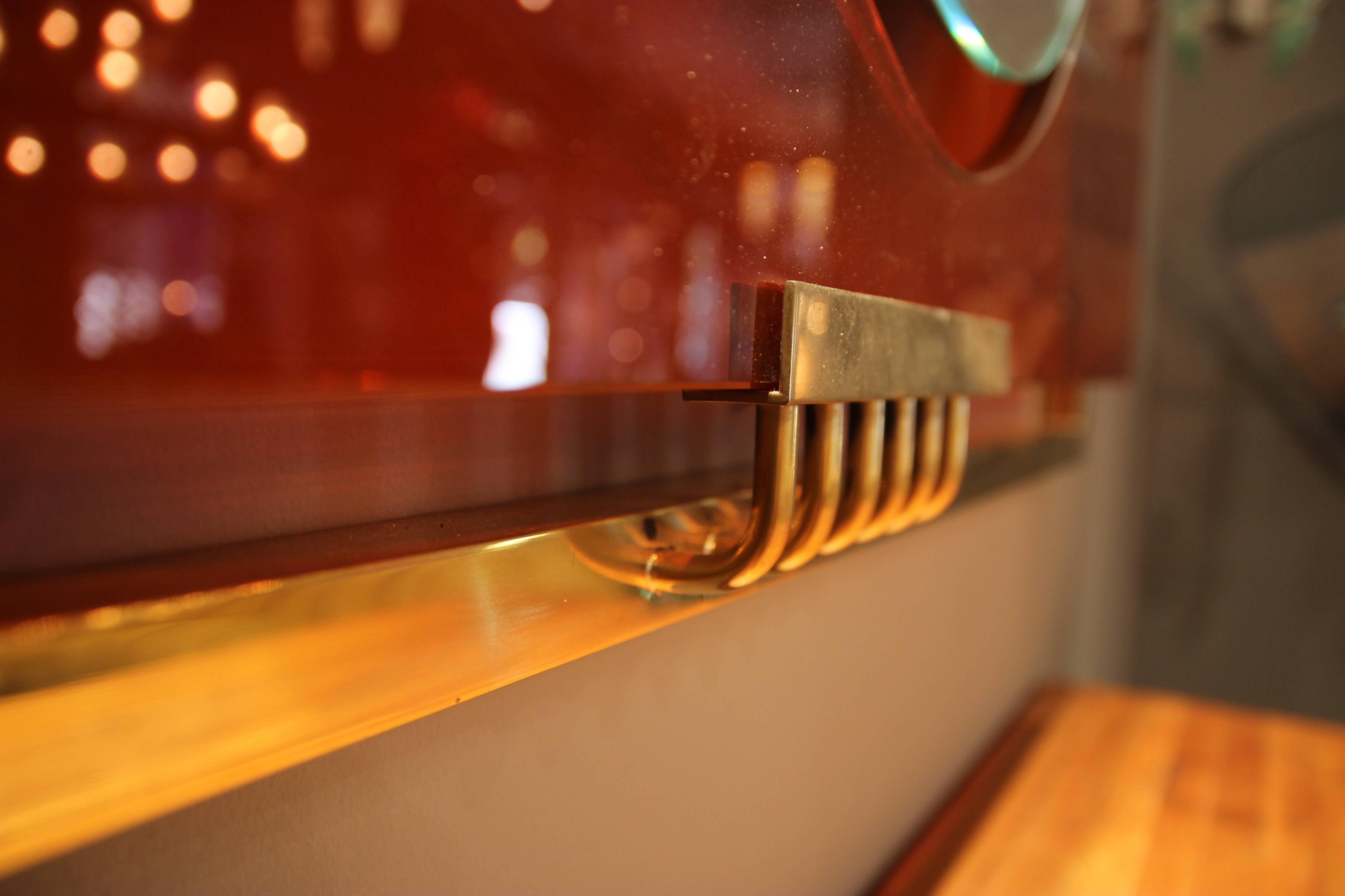 Glass Wall mirror, Gold-plated brass and orange glass, Circa 2010, Italy.