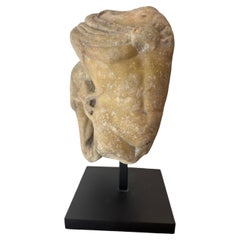 Fragment eines Flachreliefs, das einen jugendlichen Torso zeigt, der sich an ein architektonisches Element lehnt.
