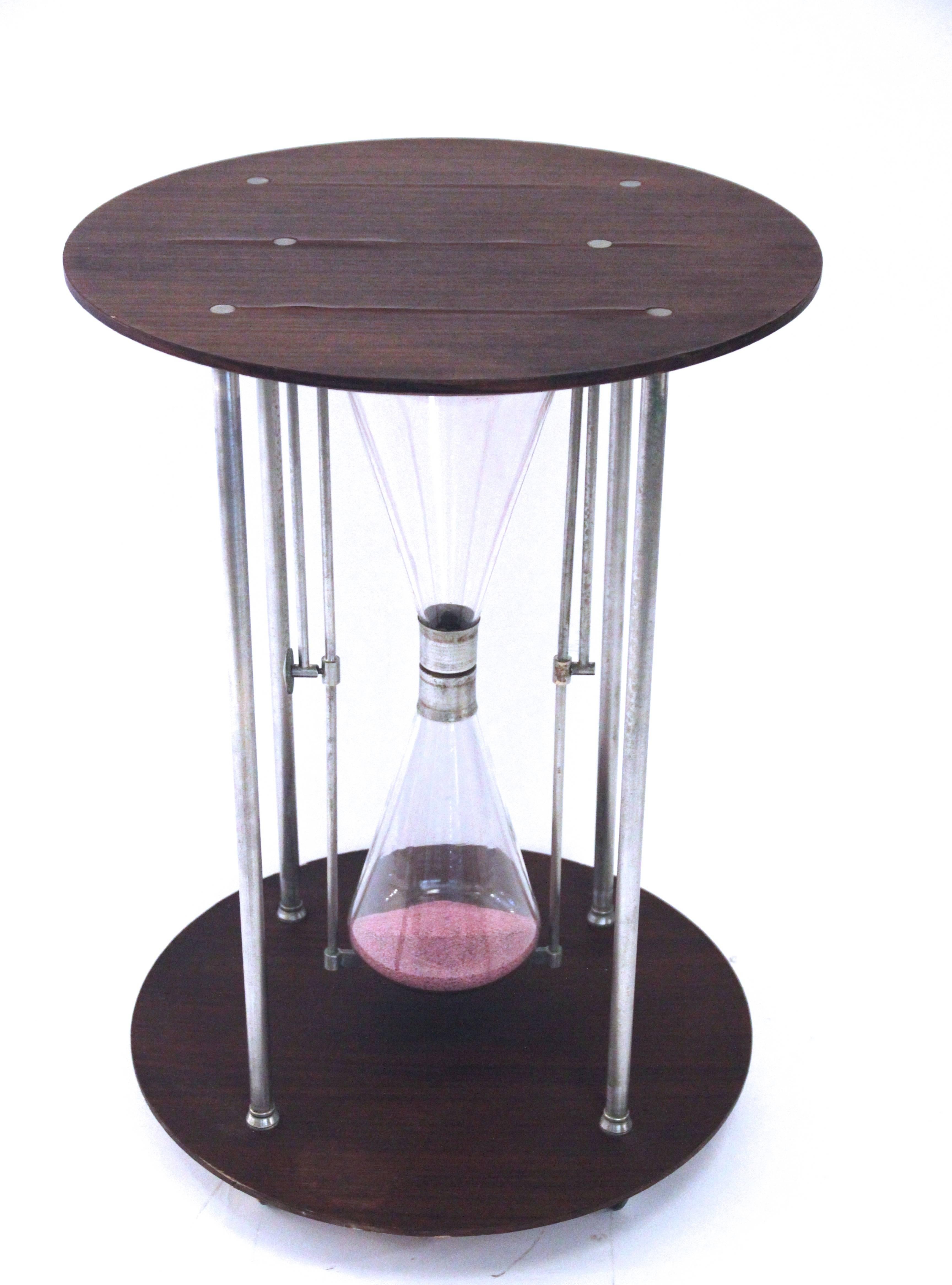 Table in hourglass shape.
Wooden trays and metal structure,
Glass hourglass,
circa 1970, France.
Measures: Height: 71 cm, diameter: 50 cm.