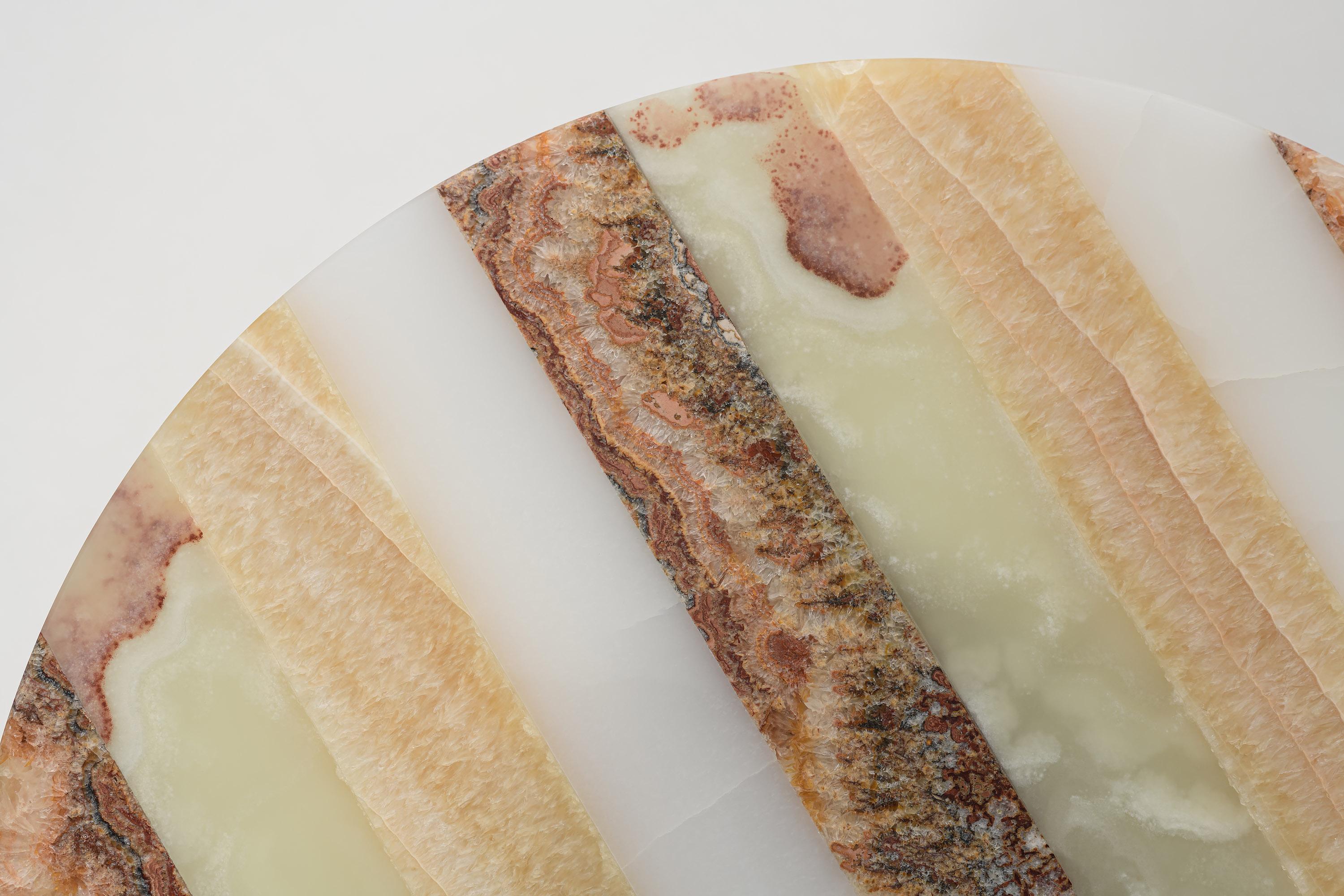 Il tavolino Frida Striped Onyx è un mobile raffinato ed elegante che darà un tocco di lusso a qualsiasi interno. Realizzato in onice naturale di alta qualità, questo tavolino è funzionale ed esteticamente accattivante e rappresenta un eccezionale