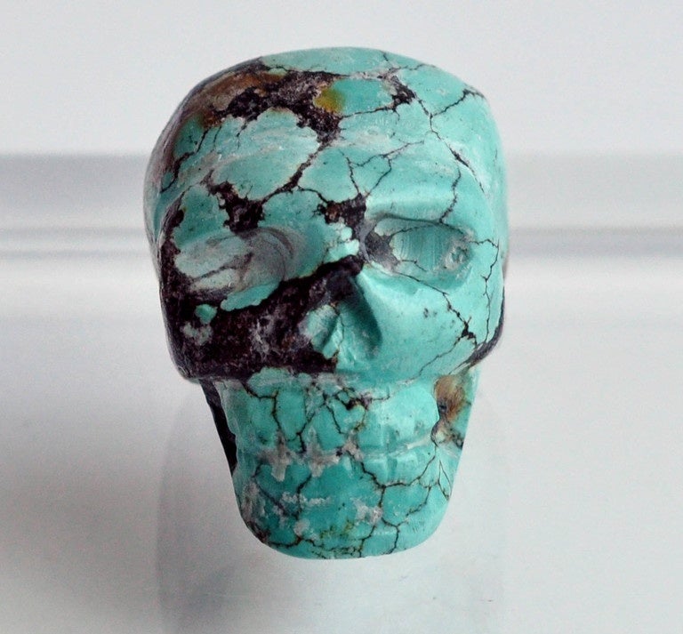 Small, carved ornamental turquoise skull probably from Western United States. Unsigned. (Includes acrylic display stand).