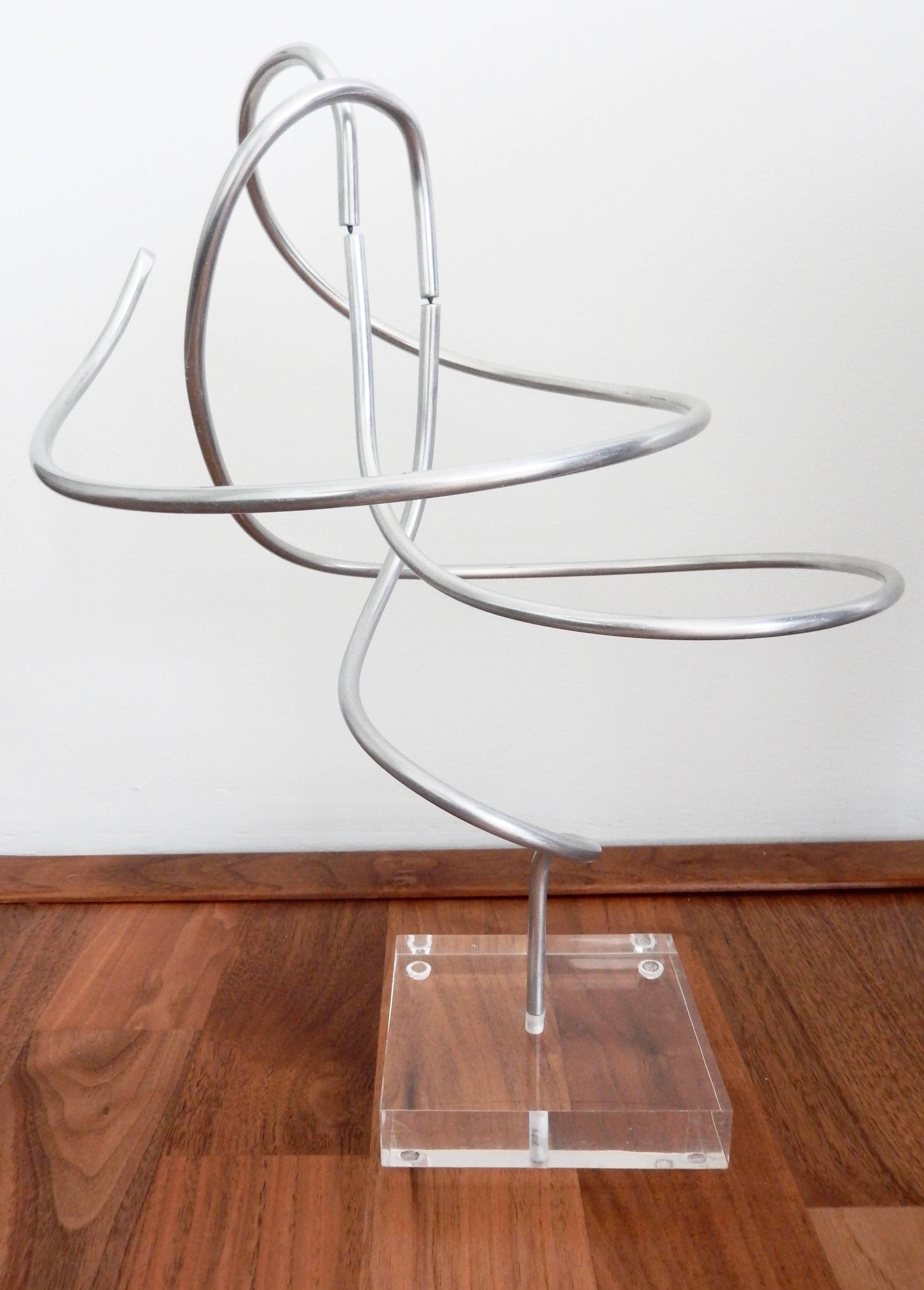 Two tubular aluminum spirals are ingeniously assembled to create this seventies Kinetic sculpture by American artist Charles Taylor. Delicately balanced, the work recalls Calder mobiles. Signed.

Plexiglass square base: 4.25 in x 4.25 in.
