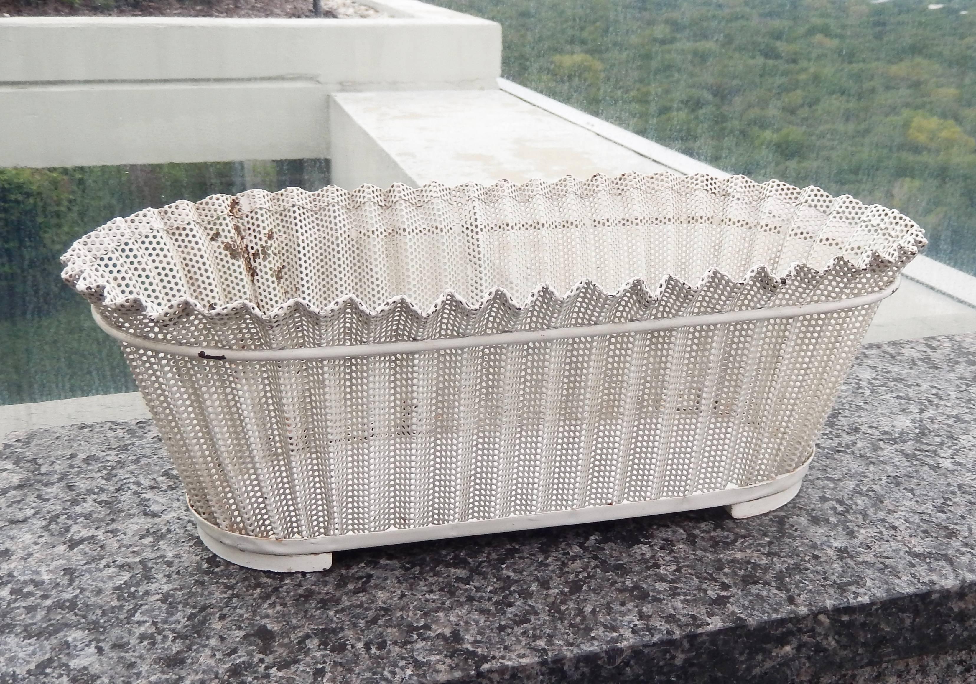 A chic, perforated metal flower basket (jardiniere rigitulle) by the modernist French designer Mathieu Matégot (1910-2001). Mategot pioneered the use of perforated sheet metal and lacquered steel in his furniture and decorative objects. Original