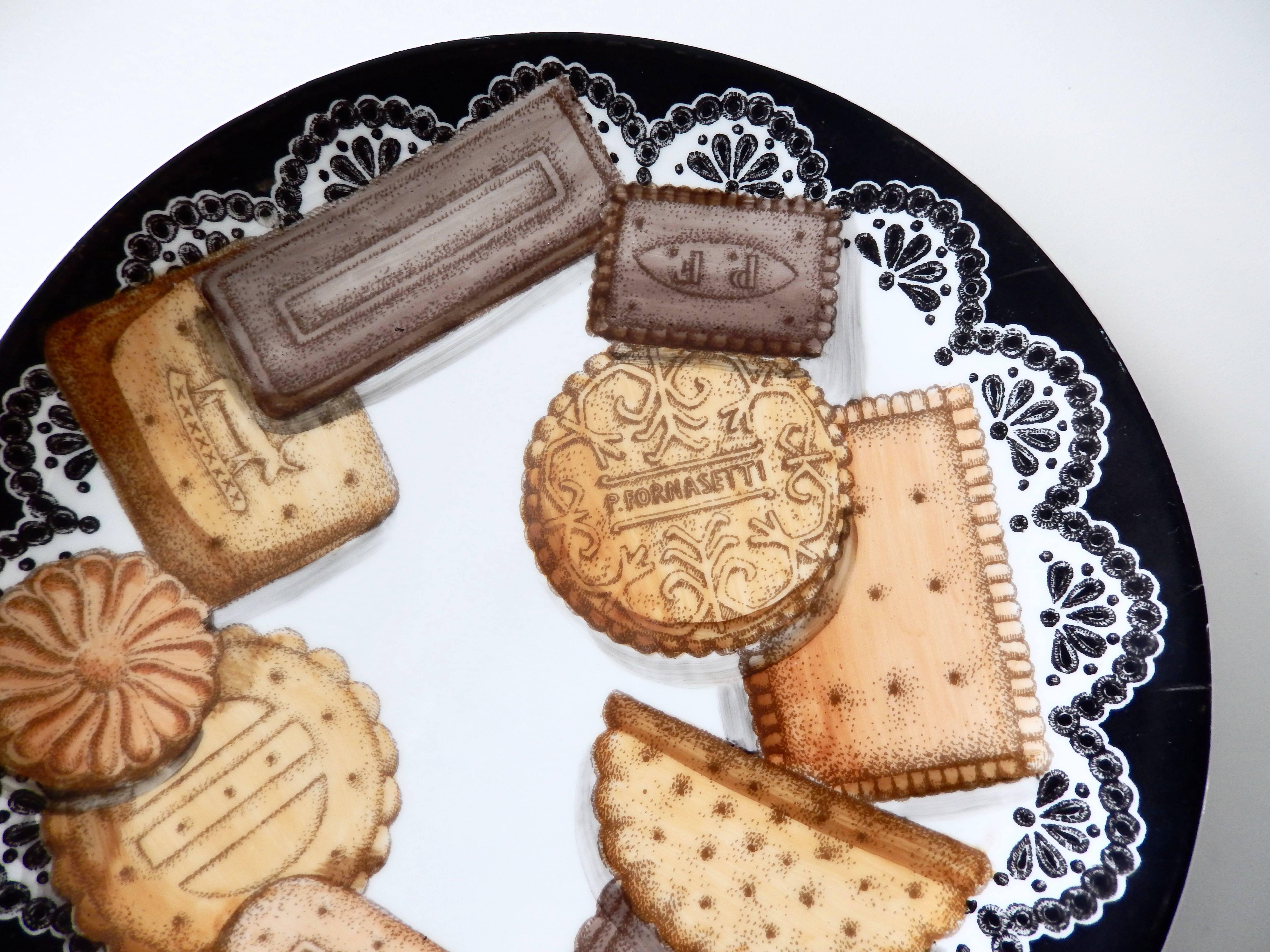 A whimsical trompe l'oeil ceramic plate by Piero Fornasetti of biscuits on a lace doily. Known for his fascination with illusionism and the surreal, this biscotti plate is a fine example of his original and amusing perspective and close attention to