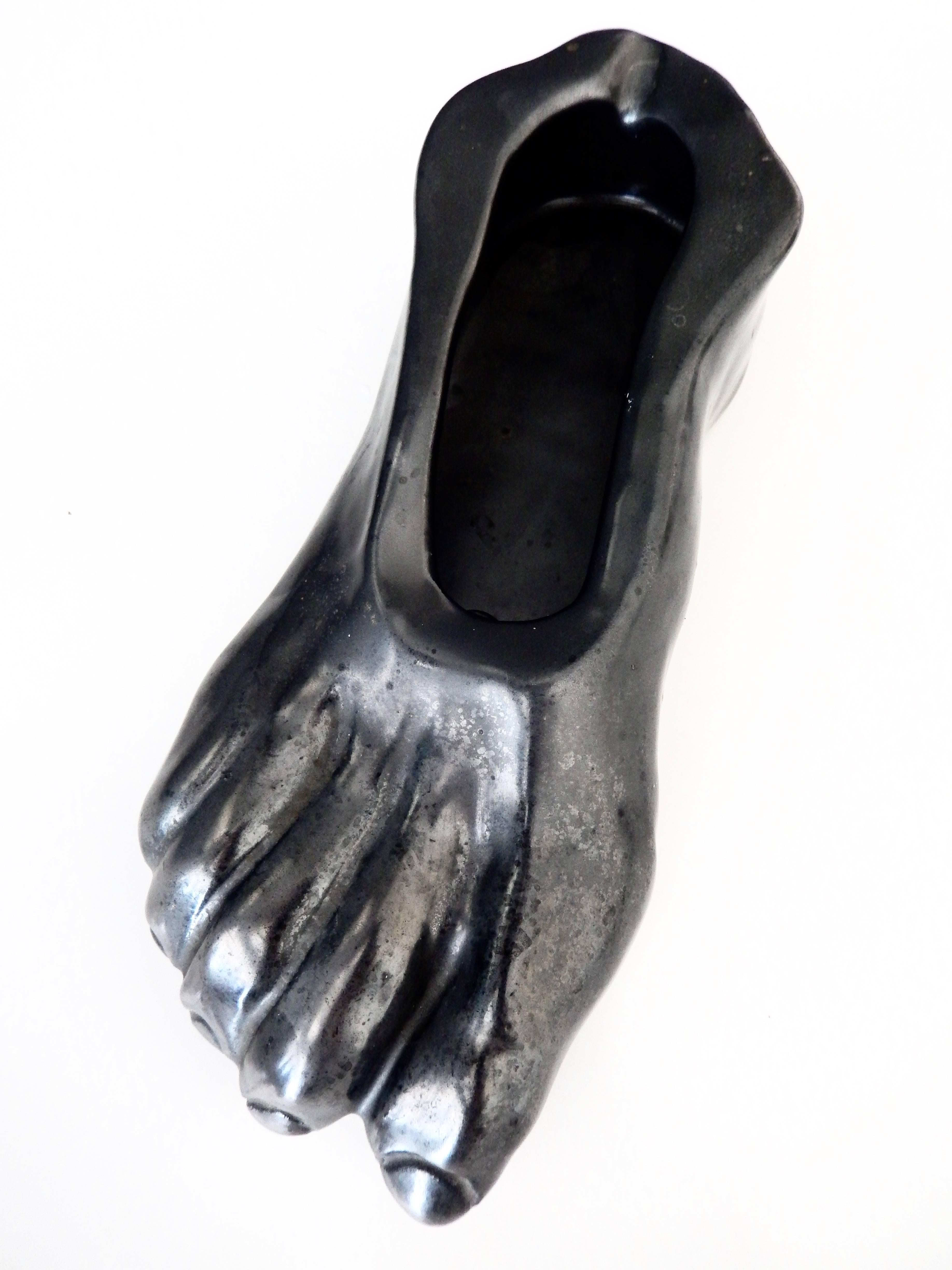 A dramatic ceramic ashtray/sculpture with a rich iridescent black glaze in the shape of a foot by the French artist, director and sculptor Jean Marais (1918-1998). Marais was the muse of Jean Cocteau and this work suggests the strong influence of