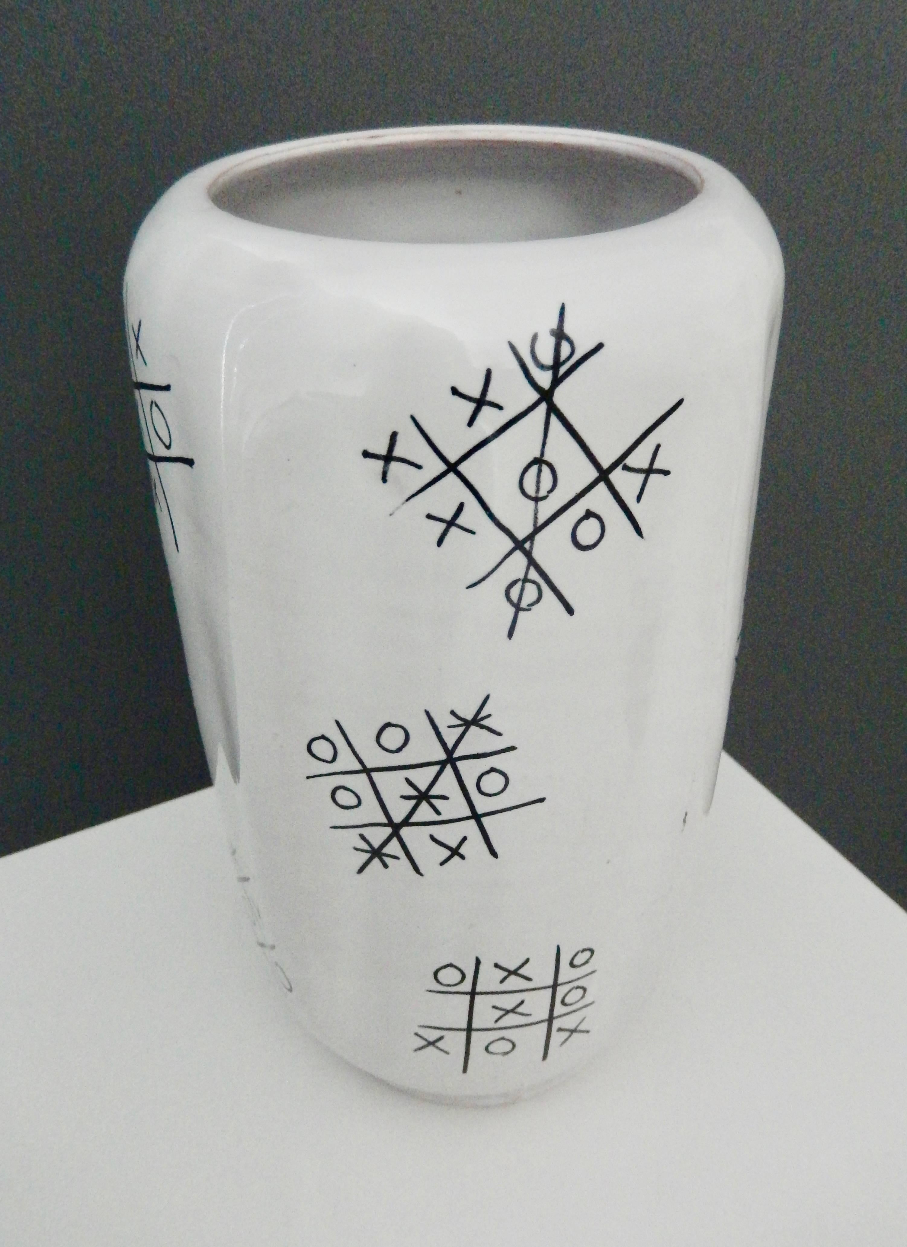 A scarce, faceted vase by Ed Langbein with a original design of several tic-tac-toe games, resembling graffiti. Since games shown are won equally by both players and some a draw, Langbein is depicting a fair game for both players. A wonderful,