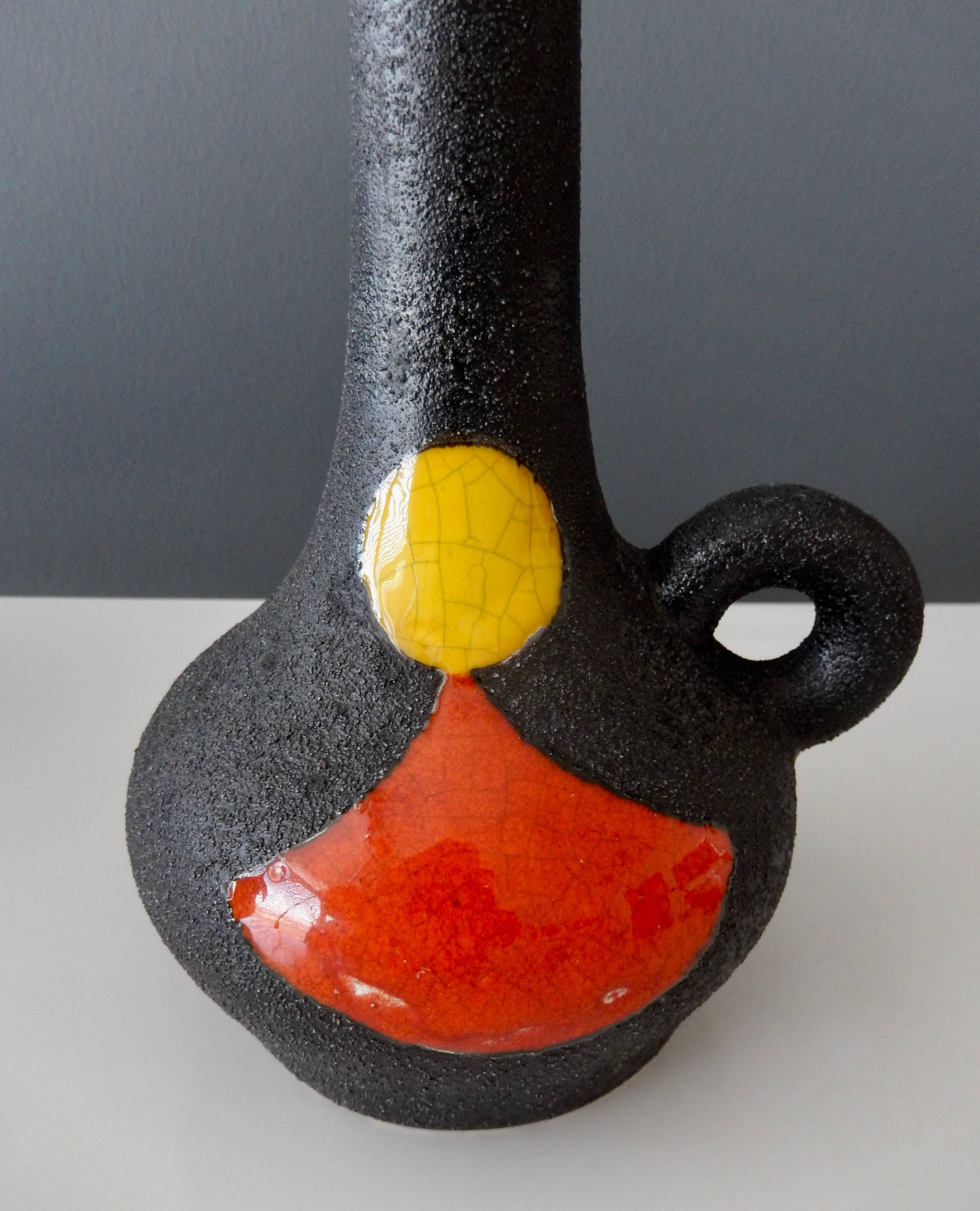 A two-color, glazed earthenware vase by the French ceramic artist Gilbert Valentin (1928-2001) with a modernist design. A master of glazes, Valentin uses striking canary yellow and burnt orange glazes against a gritty black ground to combine a