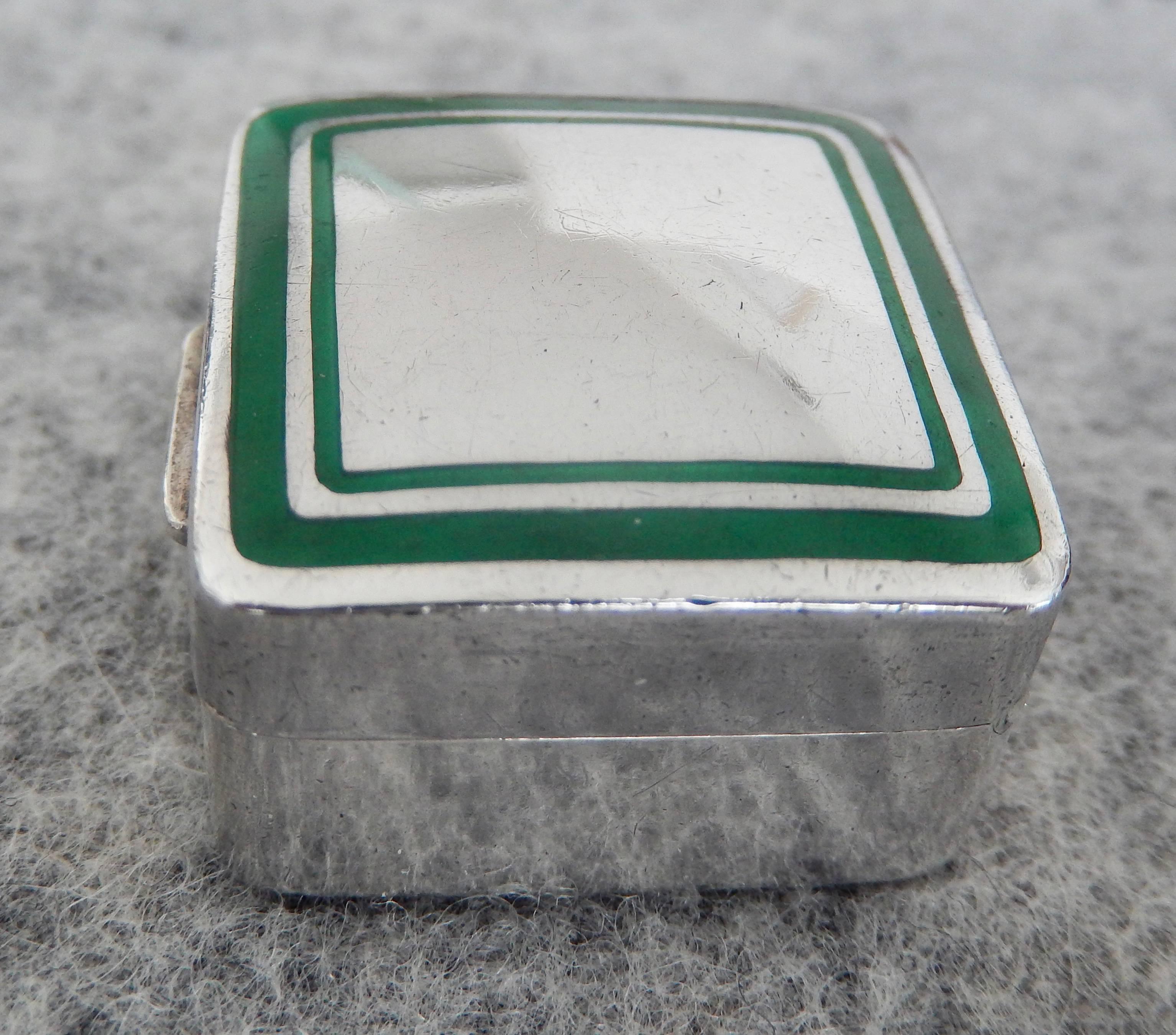 A petite 1970s sterling and green enamel pillbox by Cartier. The geometric design of a square within a square is a very attractive example of modern design from the period. C'est tres chic.
Marked 