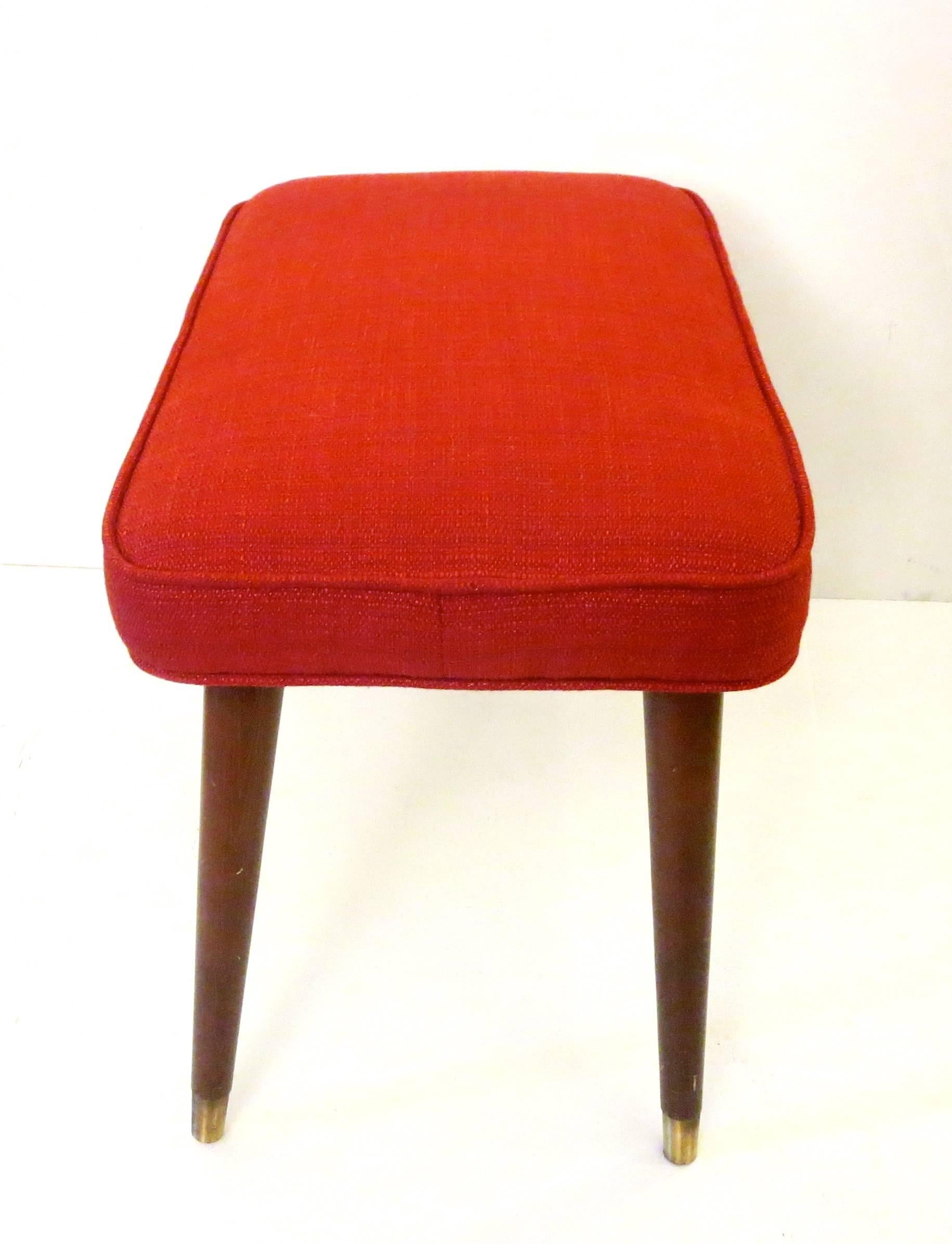 Simple elegant original footstool / ottoman circa 1950s freshly upholstered in red Knoll fabric, walnut finish tapper legs with brass polished tips, excellent condition new foam and fabric.