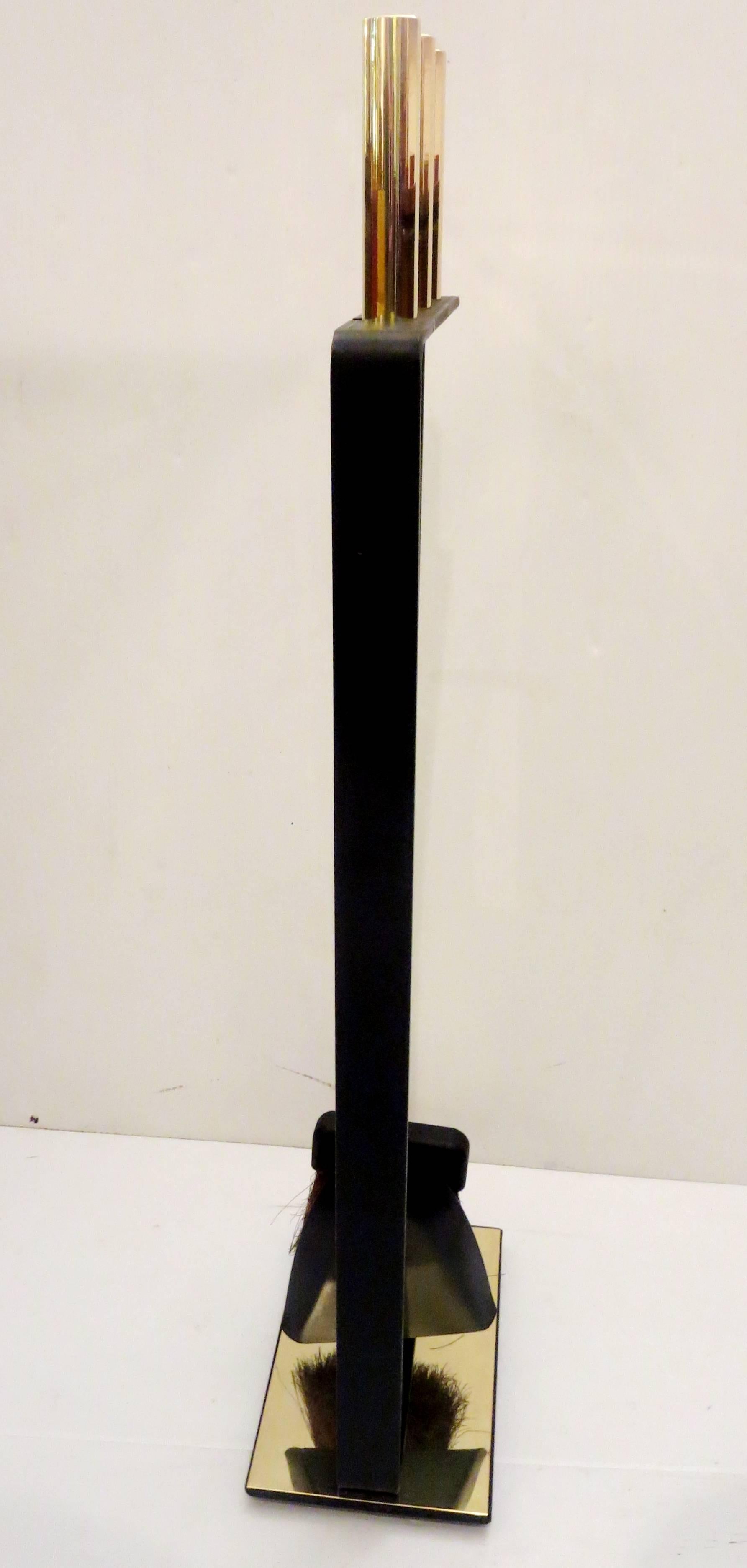 Great set of fireplace tools consisting of three instruments with polished brass cylindrical handles supported by an integral freestanding rack in wrought iron with a polished brass base. Manufactured by Pilgrim.