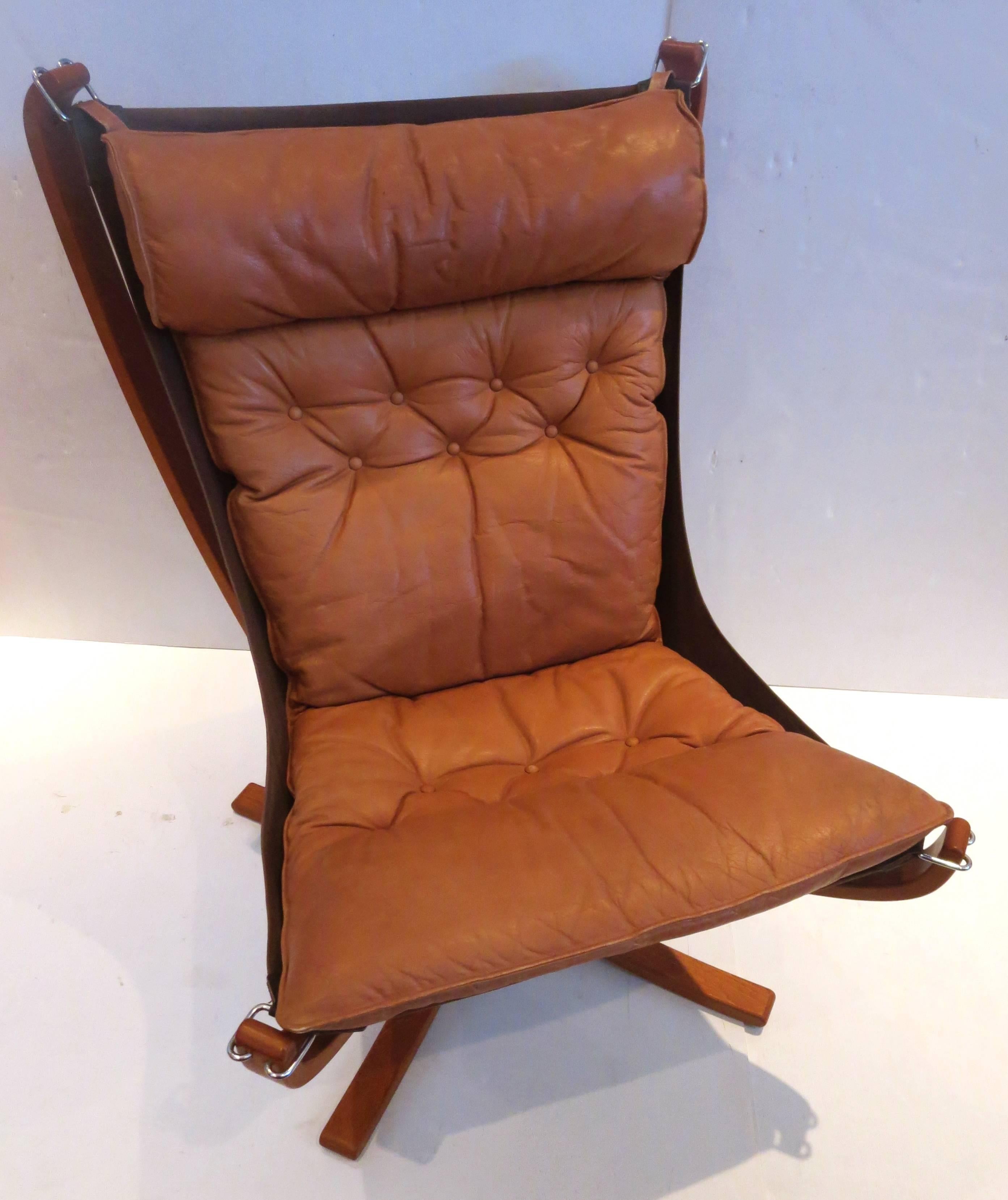 An iconic falcon chair in bentwood teak frame with leather seat cover in cognac color, circa 1970s. Nice and clean condition nicely worn leather no rips or tears, some cracking and worn as shown, solid and sturdy designed by Sigurd Russell for Vatne