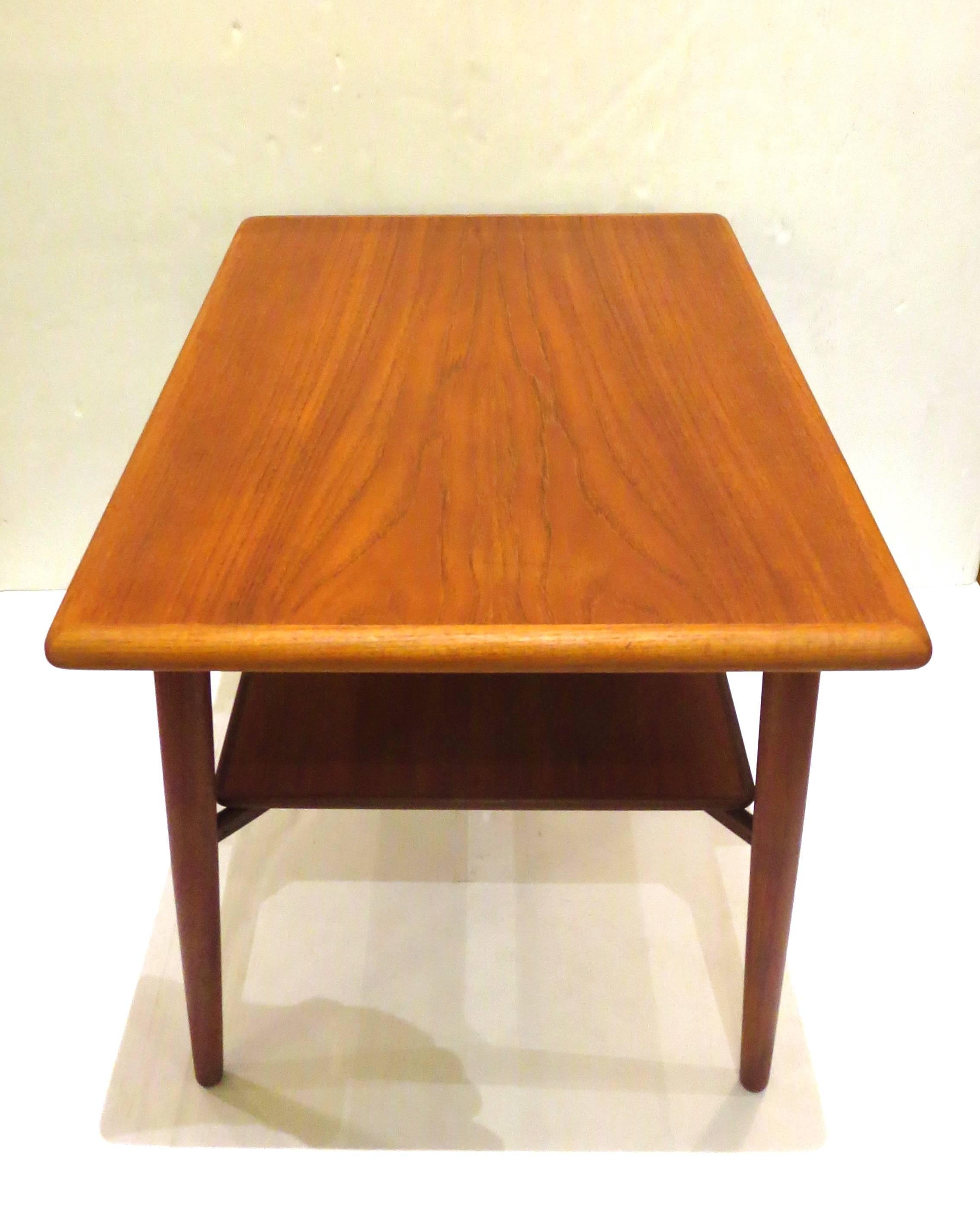 Great lines on this 1950s Danish teak end cocktail table, with shelf on the bottom, solid and sturdy freshly refinished nice grain on wood perfect for a corner or in between two club chairs.