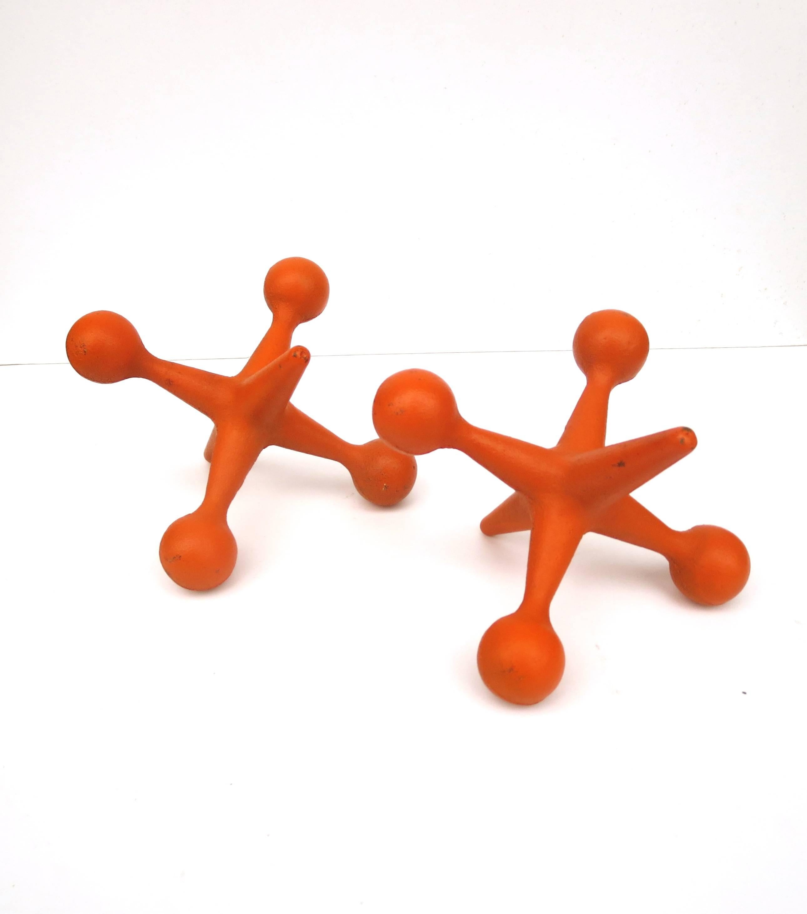 Great color on these pair of solid iron jacks, circa 1950s with enameled orange finish nicely worn.