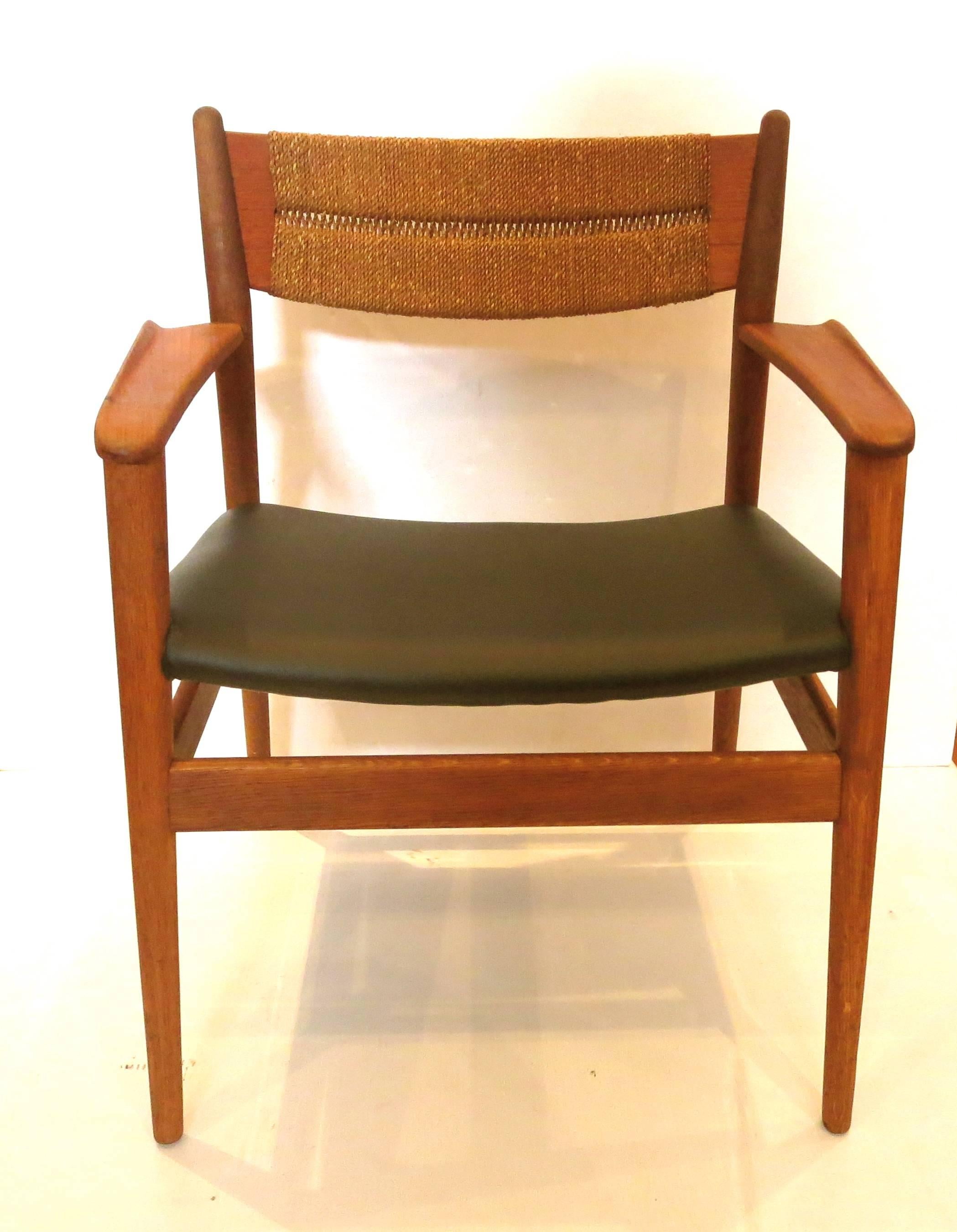 Rare pair of captain chairs, designed by Arne Vodder, circa 1950s solid oak frame with sculpted teak arms, seagrass backing and freshly recover in black Naugahyde, we restore them and they are solid and sturdy a very rare and great design chair by a