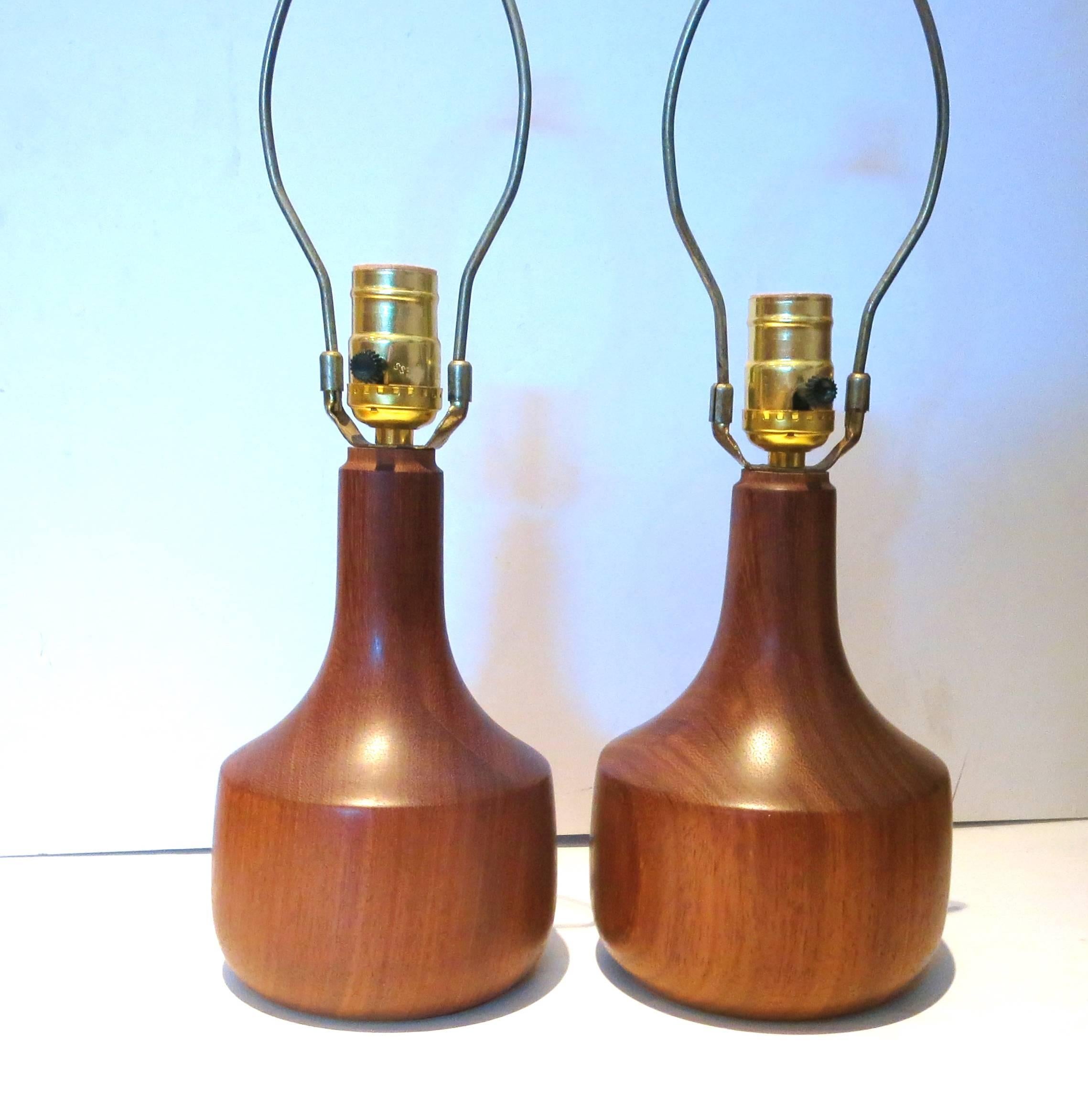 Simple elegant pair of solid sculpted teak table lamps freshly refinished, circa 1950s. Rewired and in perfect condition, lampshades not included, measures 11