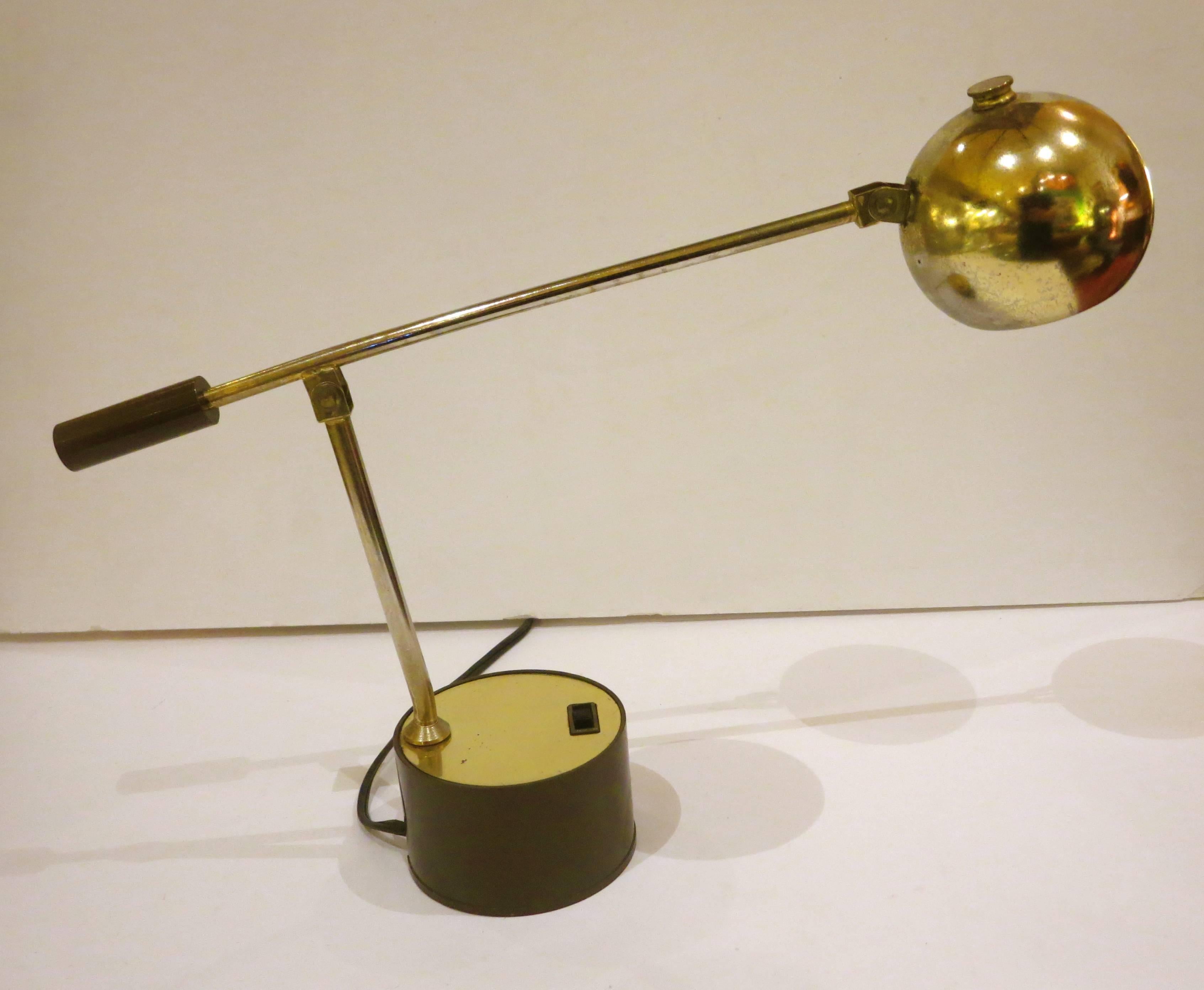 Cool and unique small table lamp, circa 1960s, multidirectional double intensity high and low switch with polished brass and plastic base the shade rotates to 360 degrees and the arm moves up and down, also the shade moves up and down and rotates.