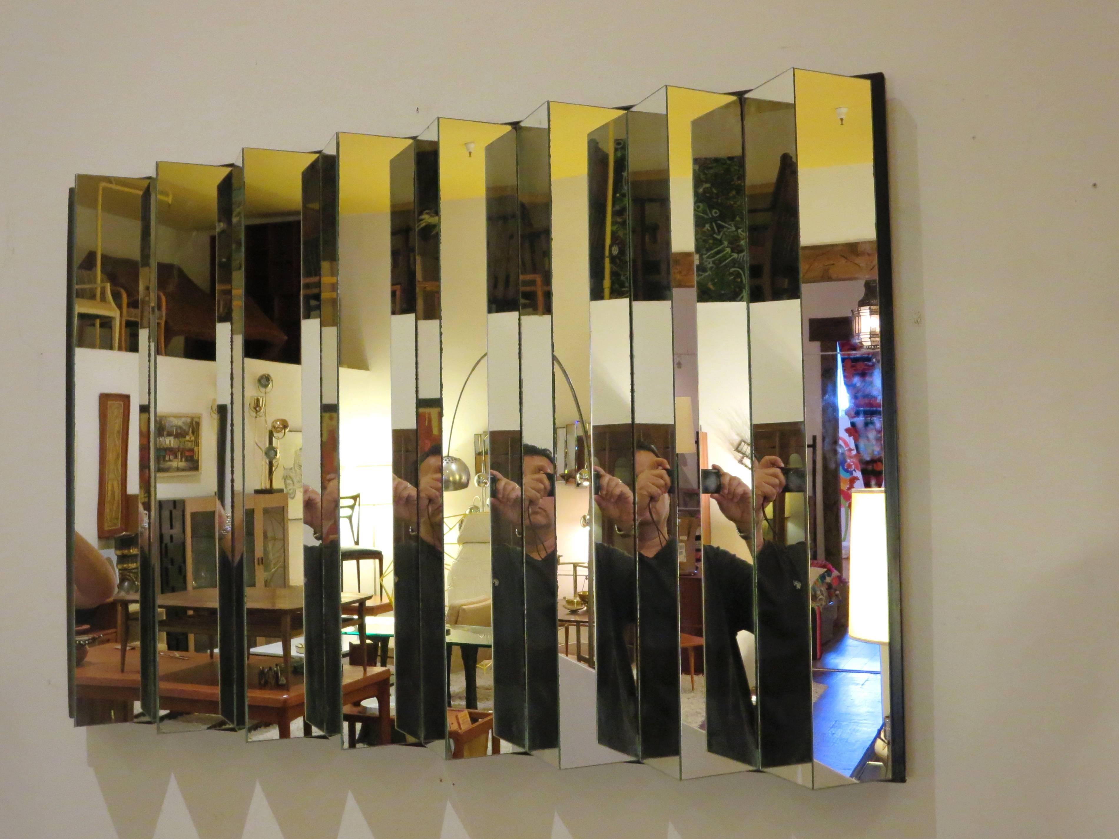 Incredible rare zig-zag multifaceted mirror, wall-mounted, can be hang vertical or horizontal, circa 1970s, with black plastic base on top of wood, no chips or cracks only natural imperfections due to age on the edge as shown, the mirrors were done