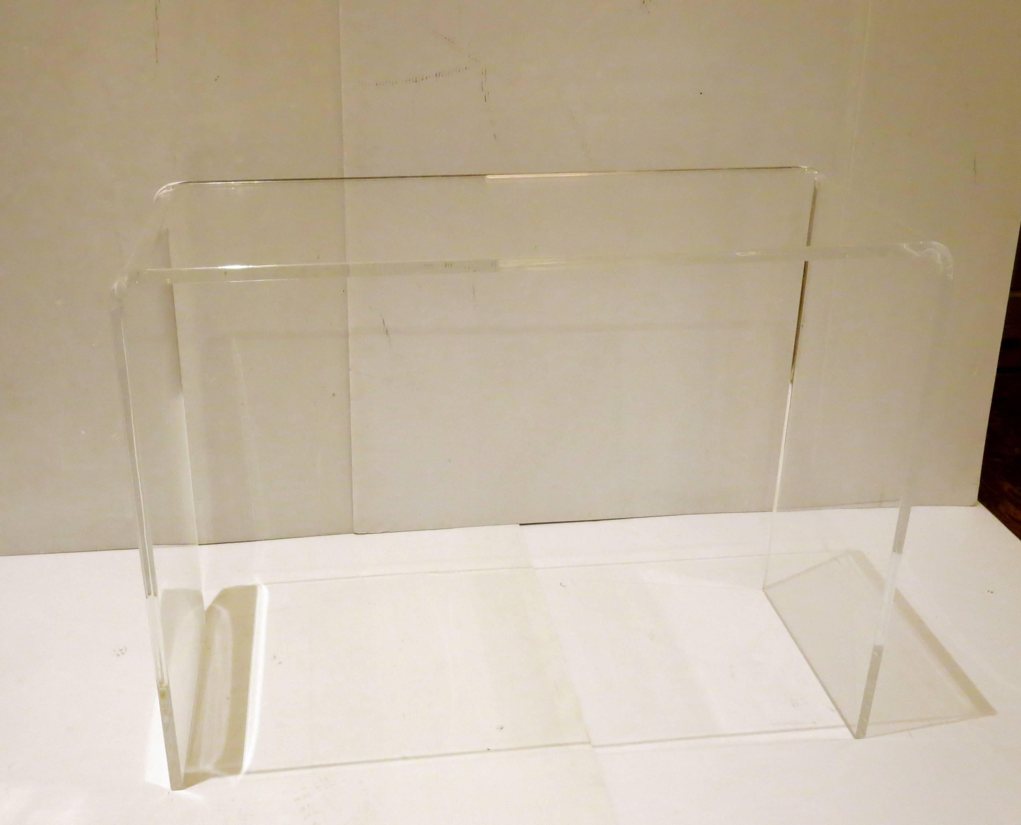 Wonderful Lucite waterfall console table or desk in the style of iconic furniture designer and manufacturer Charles Hollis Jones. With its simple form and use of material this piece will work with many interior styles. Lucite is 3/4