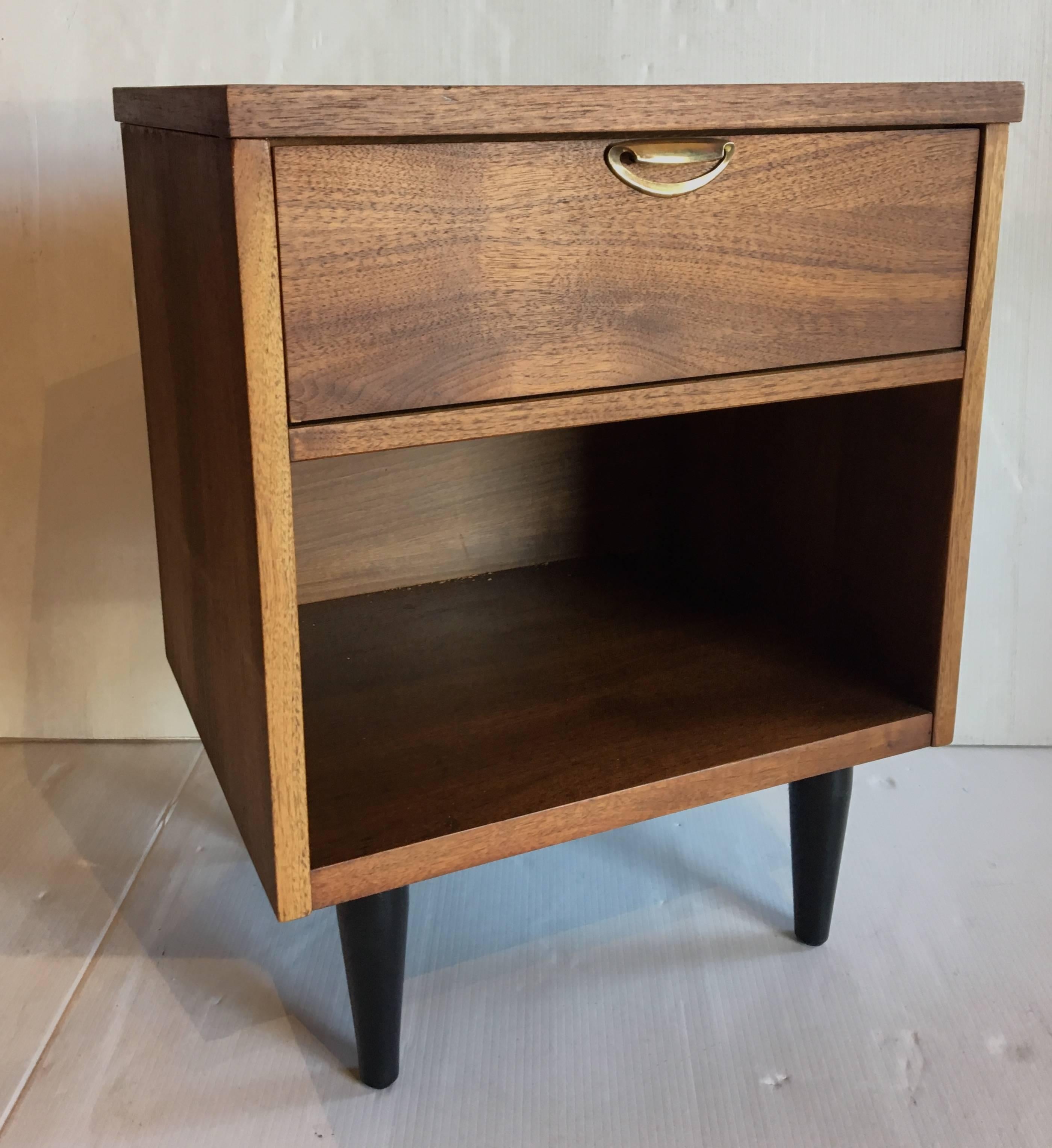 Nice pair of nightstands circa 1950s, American walnut with brass polished pulls and black lacquer taper legs, freshly refinished sanded and finished with hand rubbed oil finish, nicely crafted with dovetail drawers.