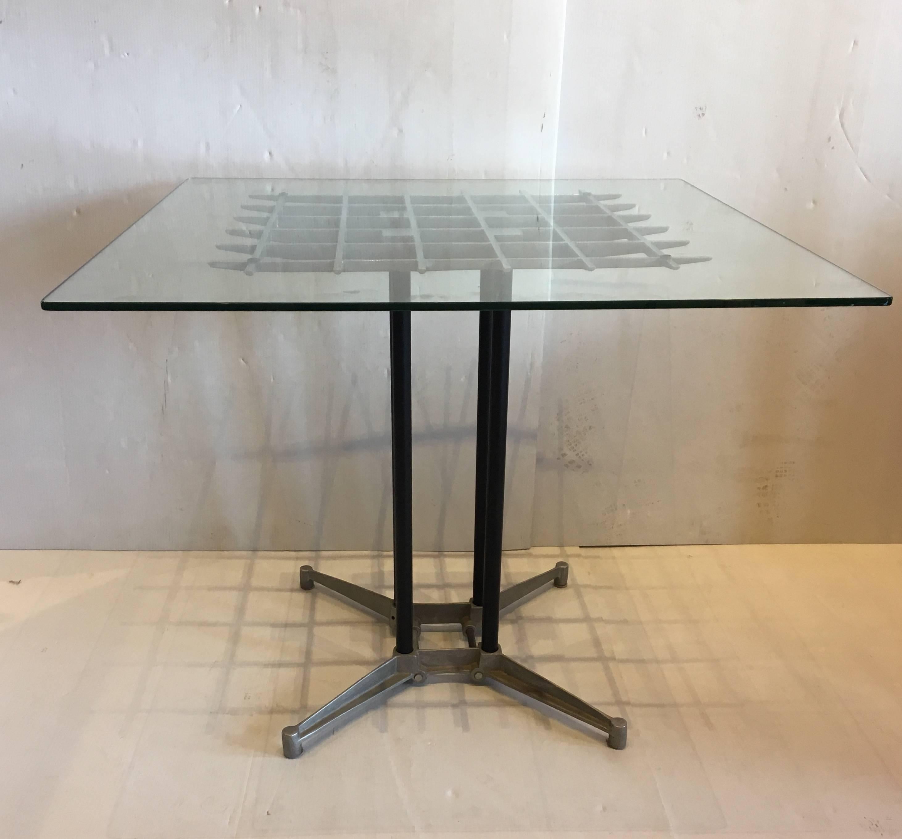 Great design on this polished aluminum dining table, with grill top and four black enameled pipe posts, designed by Robert Josten, circa 1980s. California designer with a glass top that can be replaced with a larger one if need it.