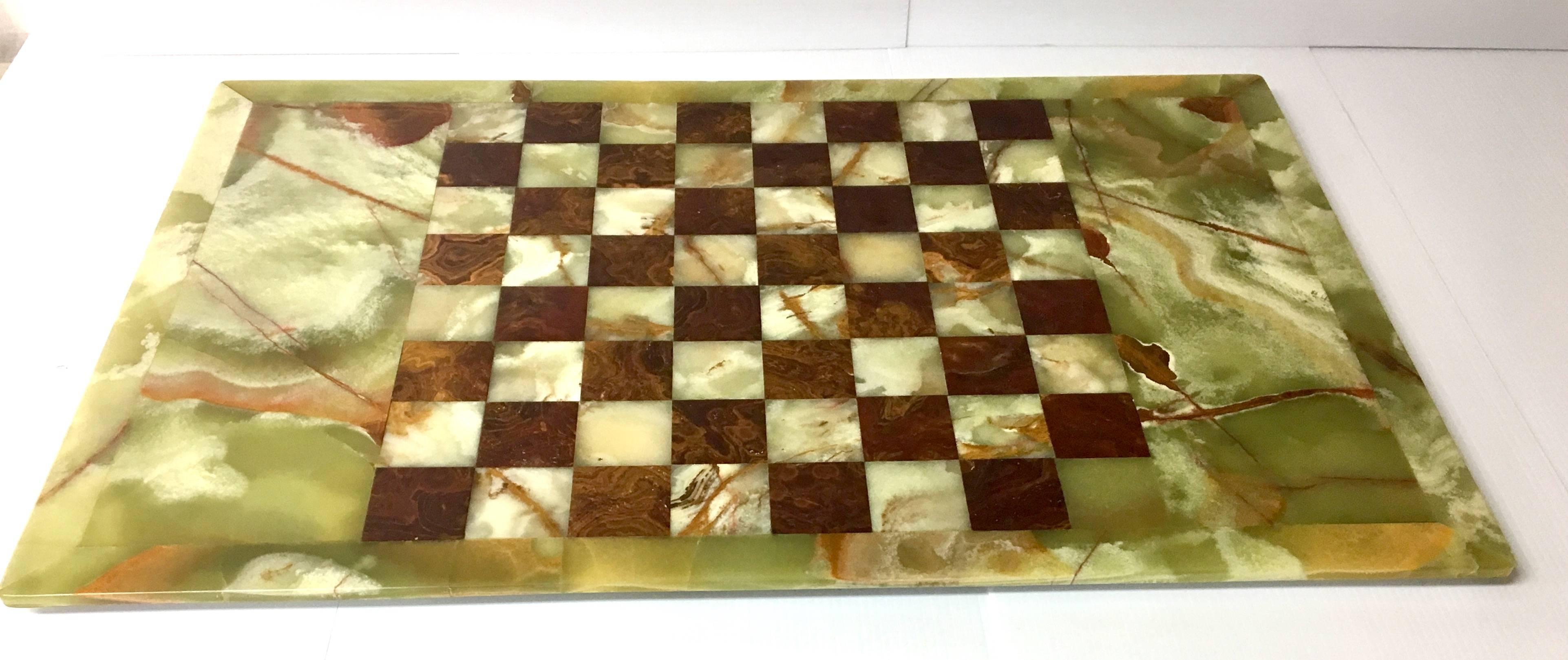 Beautiful chess set in the style of Frederick Weinberg on an oversized onyx chessboard. The chess pieces are heavy Greek style figures in a patinated brass finish and a darker bronze finish; each figure measures for 2