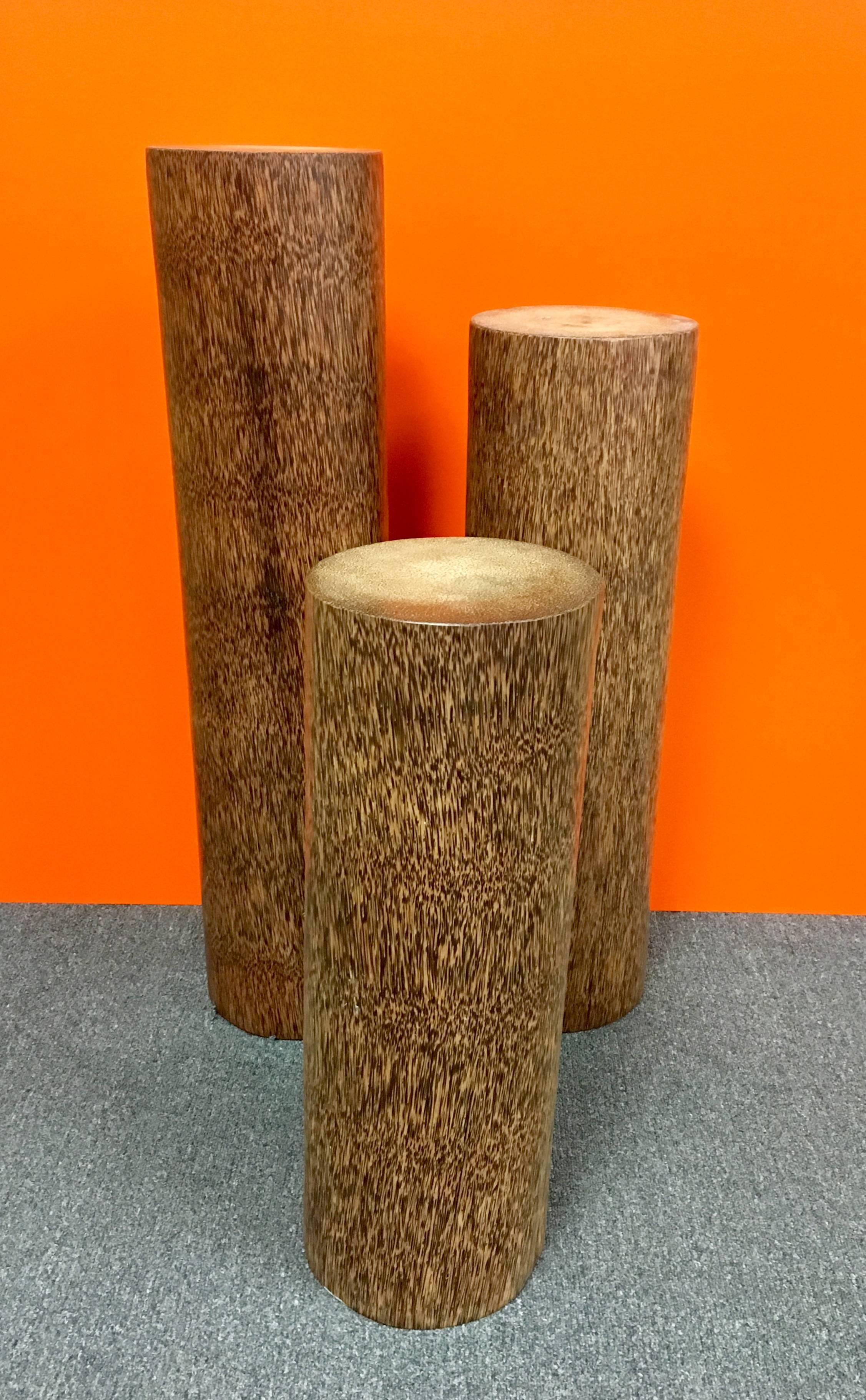 Unique set of pedestals made of solid coconut / palm wood from the trunk of the tree. Nicely finished with a great wood grain pattern; the pedestals are very heavy and solid. The tallest pedestal is 37 1/2
