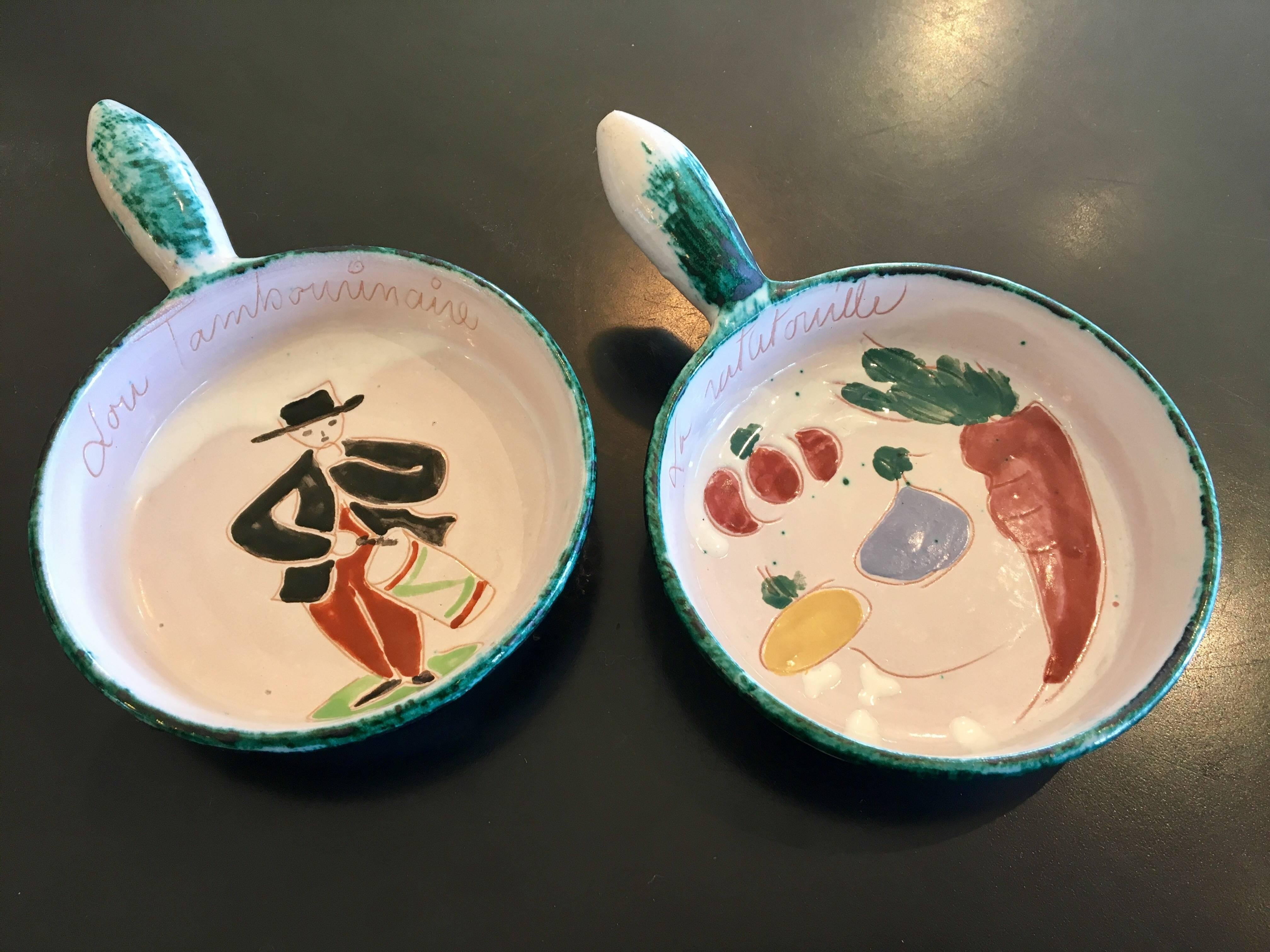 Rare and unique pair of hand-painted, ceramic, small casseroles made in France, circa 1950s. No chips or cracks with perforated handles to hang on the wall. In the style of Picasso for Vallauris.