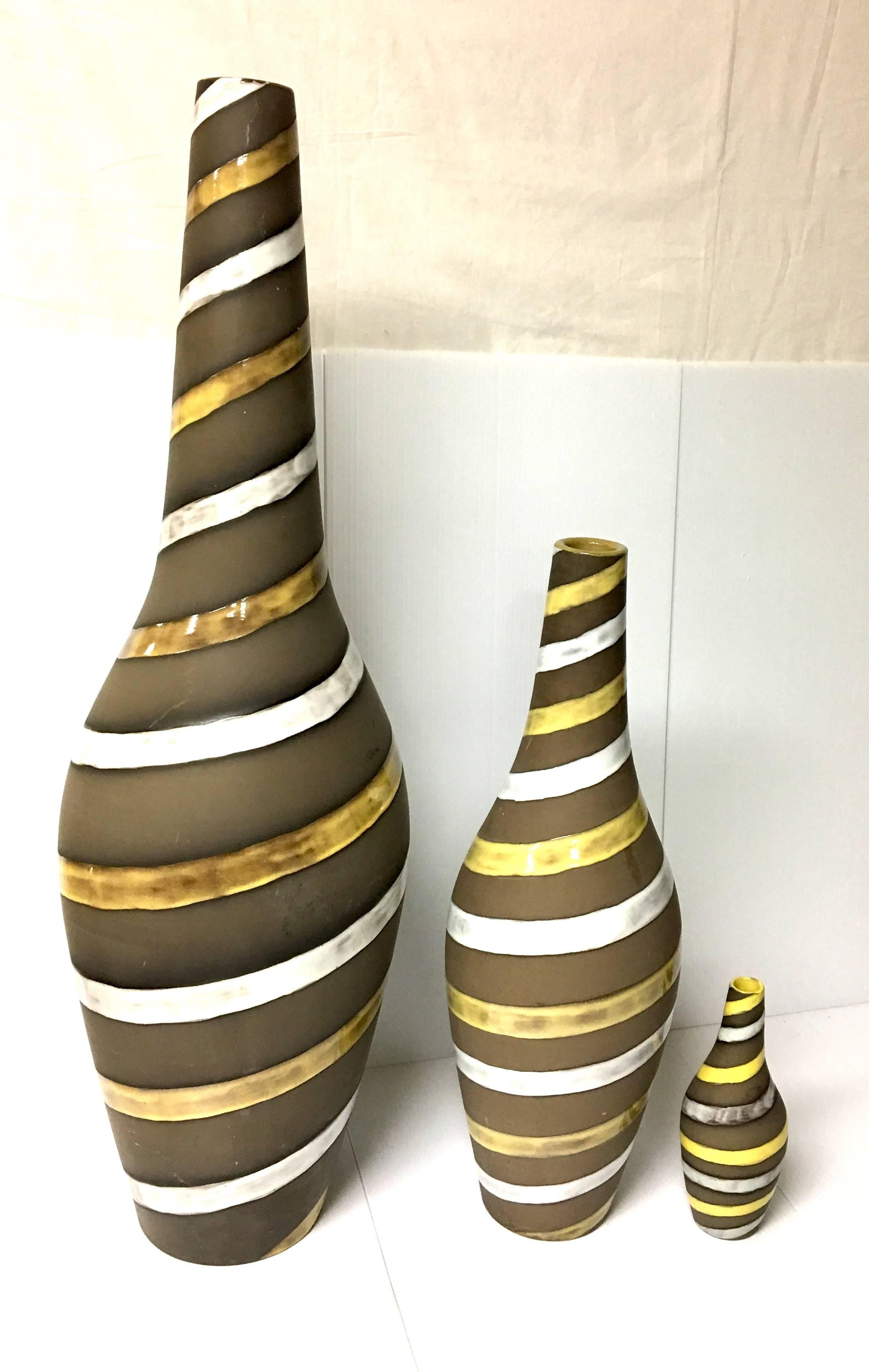 Rare and hard to find trio of striped ceramic vases, designed by Ingrid Atterberg for Upsala Ekeby in Sweden. The vases are in excellent condition, measurements are as follows: the tallest is 31" X 10" in diameter, the middle its 20"