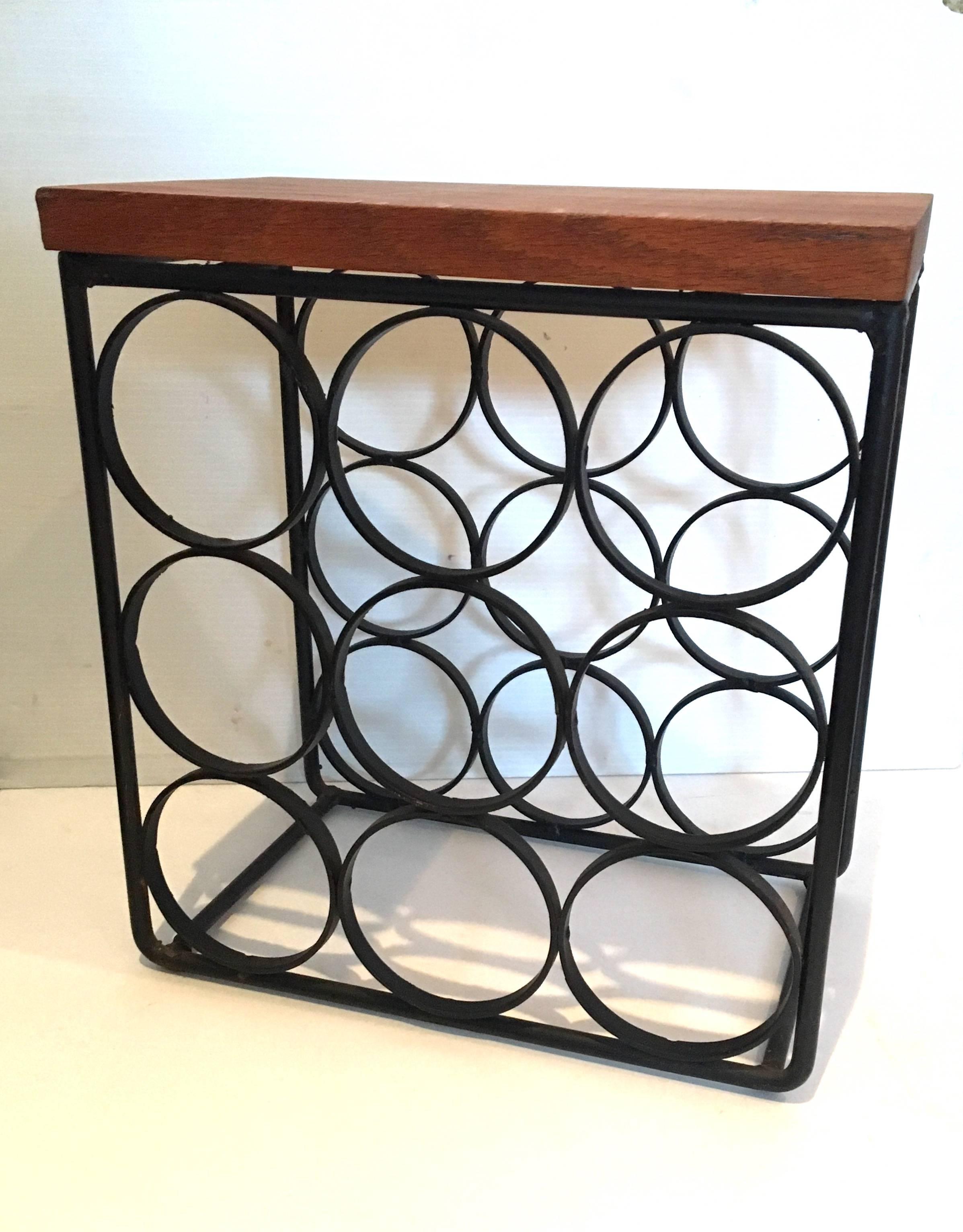 Solid iron nine bottle capacity wine rack. With solid wood cutting board, circa 1950s. Designed by Arthur Umanoff California design.