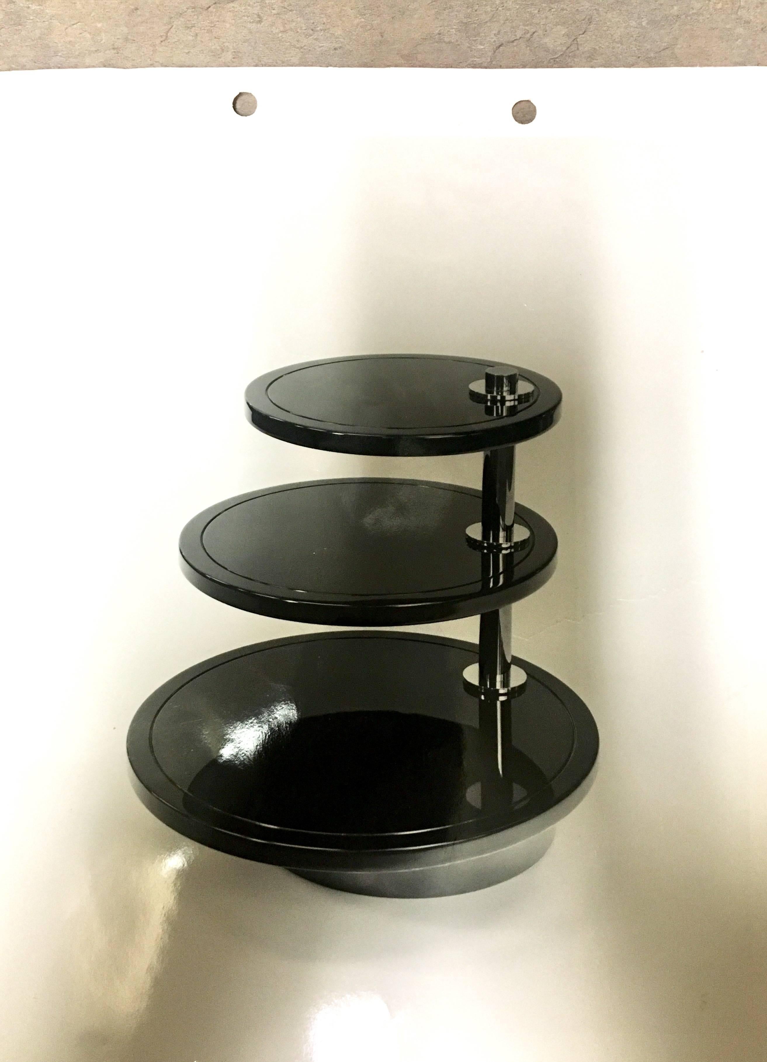 A rare custom order three-tier cocktail table by Robert Metzger with original paperwork manufactured in 1980. The table consists of three beige lacquer finish discs with a chrome pole and brass accents; the discs are rotatory table tops and can be