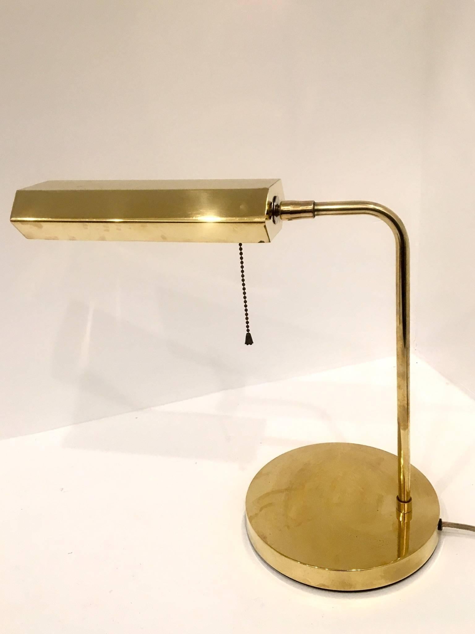 Elegant Minimalist design on this polished brass desk lamp, circa 1970s with pull off/on chain and multidirectional lampshade moves up and down and side to side.