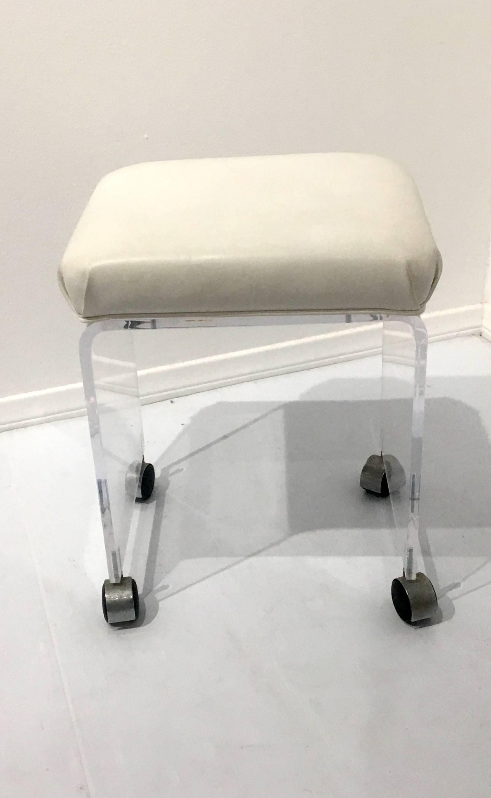 Versatile solid Lucite waterfall vanity stool, with chrome casters circa 1970s. In white Naugahyde nice and clean condition with chrome casters.
